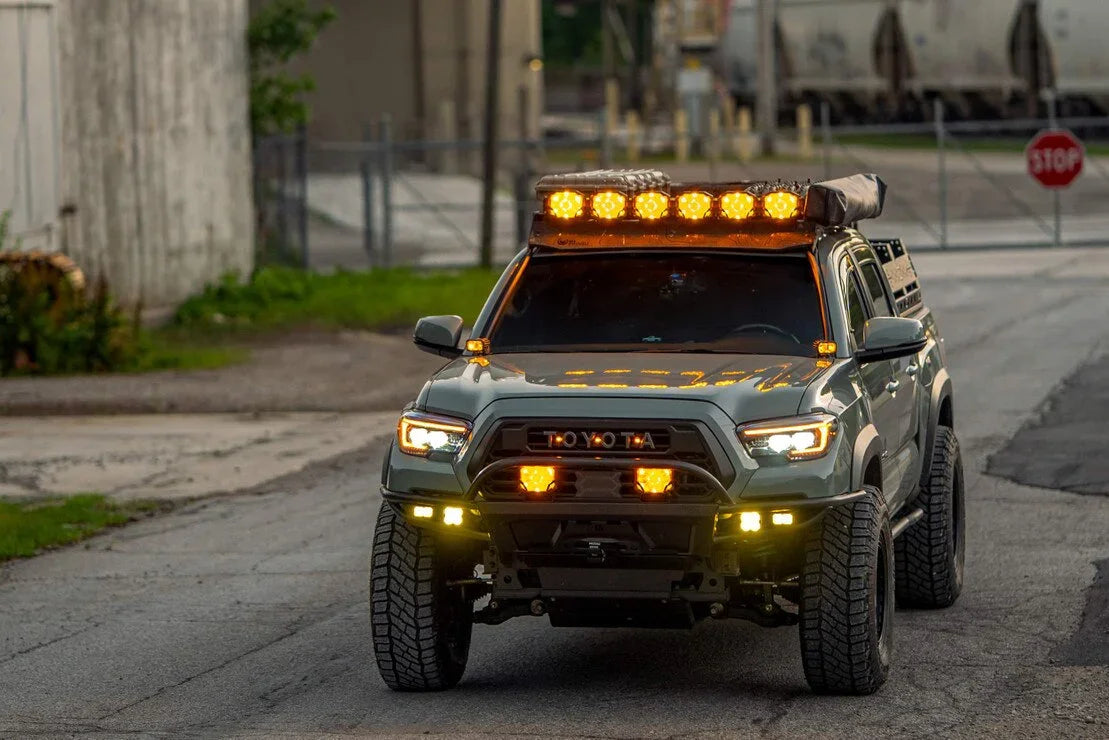 Toyota Tacoma with custom XB Evo headlights and amber off-road lights on urban street