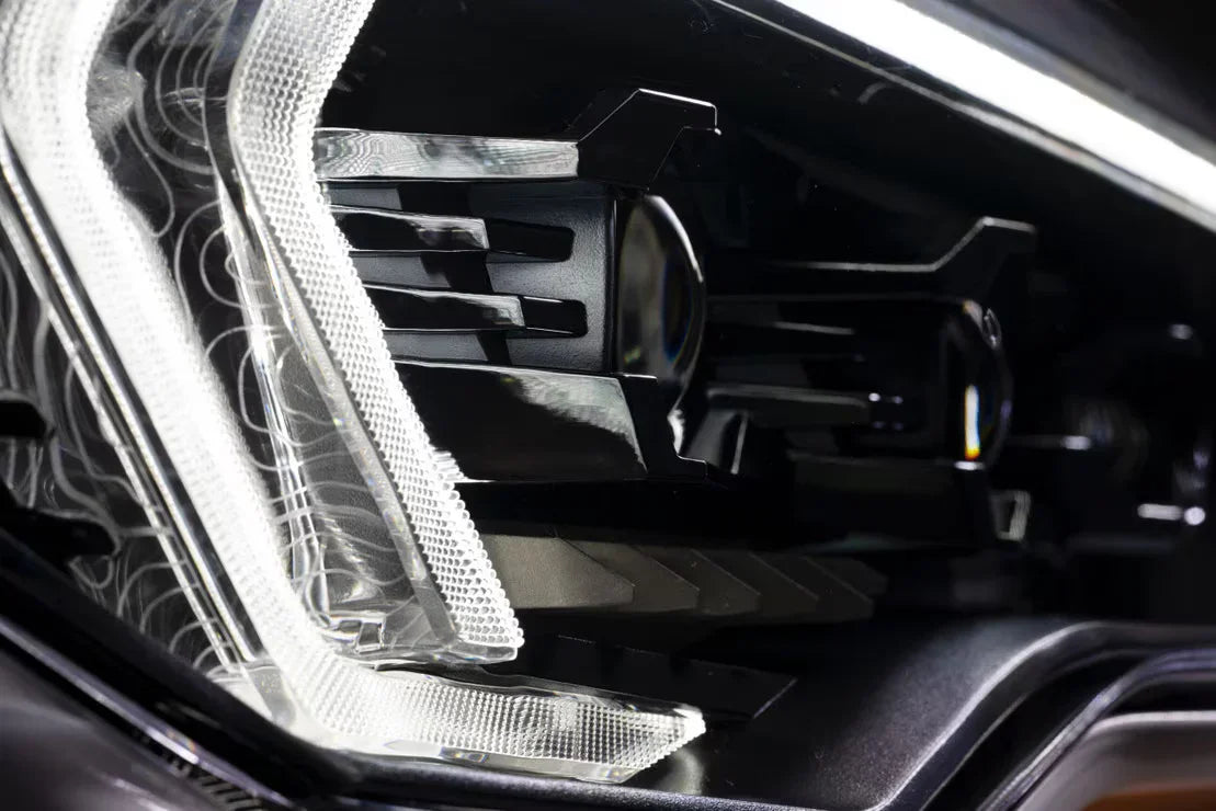 Close-up of a modern LED off-road vehicle headlight with black housing and clear lens.
