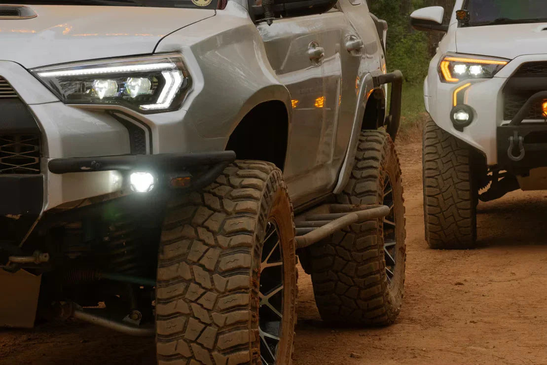 Off-road Toyota 4Runner SUVs with large mud-terrain tires on a dirt trail