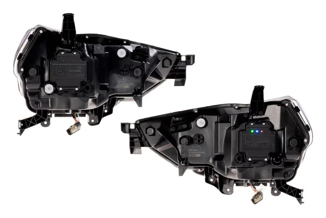 Pair of black automotive headlight housings with wiring harnesses for off-road vehicles