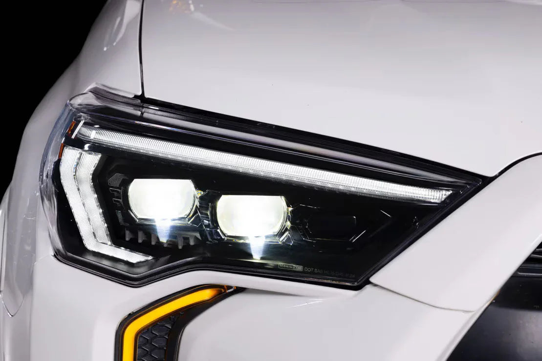 Close-up of LED headlight on white Toyota Tacoma with modern design accents