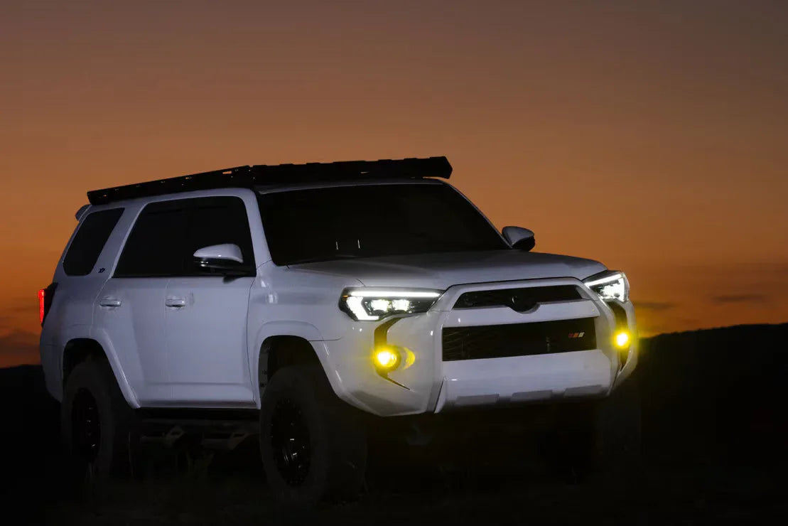 White Toyota 4Runner with off-road mods and roof rack at sunset, adventure vehicle