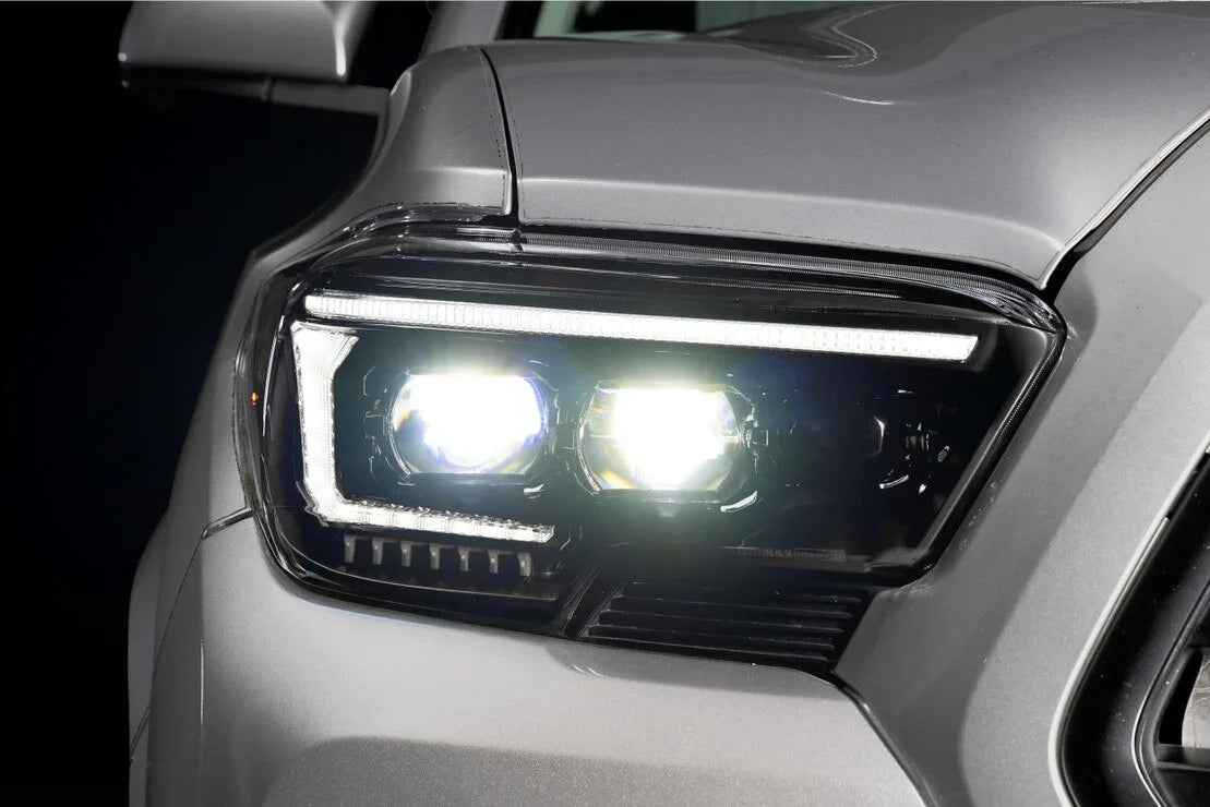 Toyota Tacoma XB Evo hybrid LED headlights illuminated on grey truck