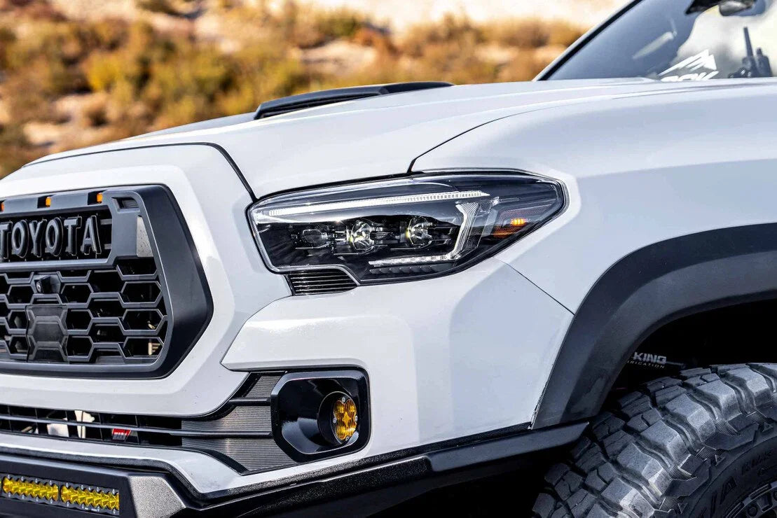 Close-up of Toyota Tacoma front passenger side with aftermarket hybrid headlights and off-road accessories