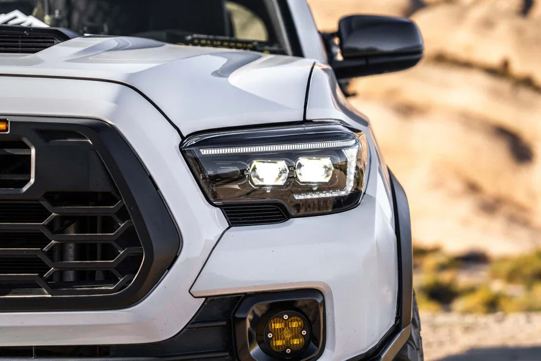 Close-up of Toyota Tacoma with XB Evo hybrid LED headlights and yellow fog light, outdoors