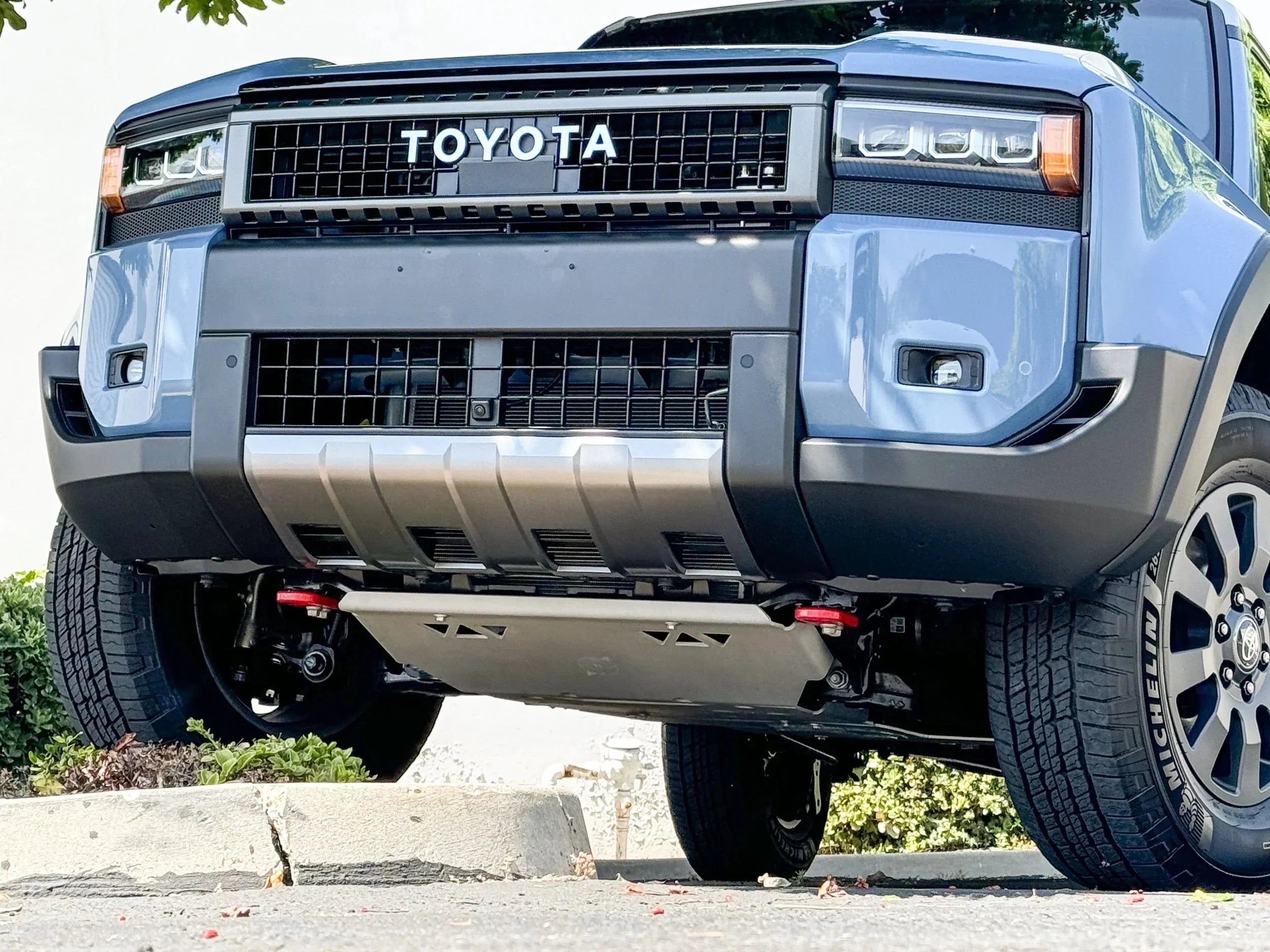 Front view of Toyota off-road SUV with skid plate and rugged suspension, parked outdoors