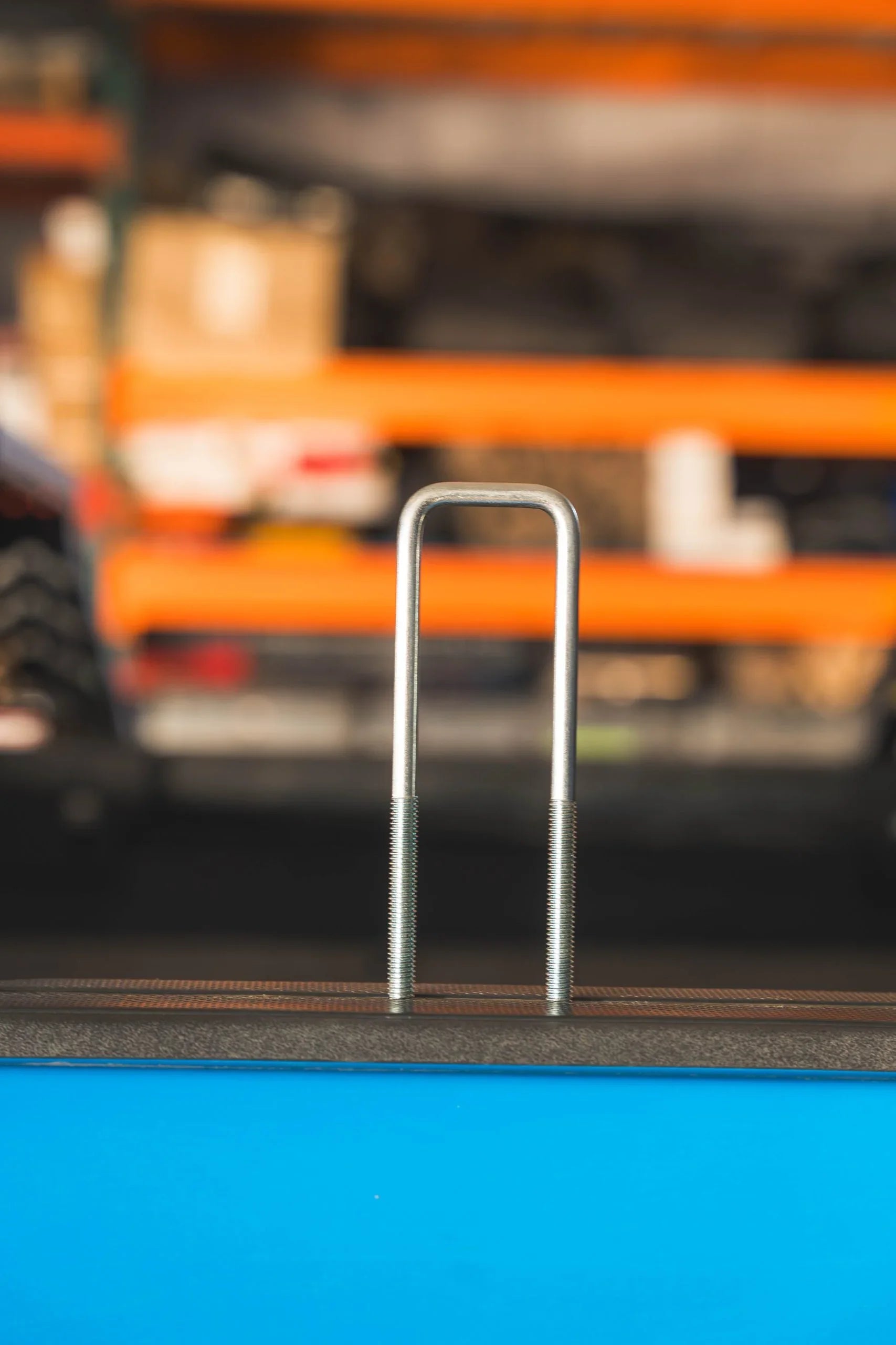 Steel U-bolt with threaded ends for vehicle rack mounting, overlanding gear background