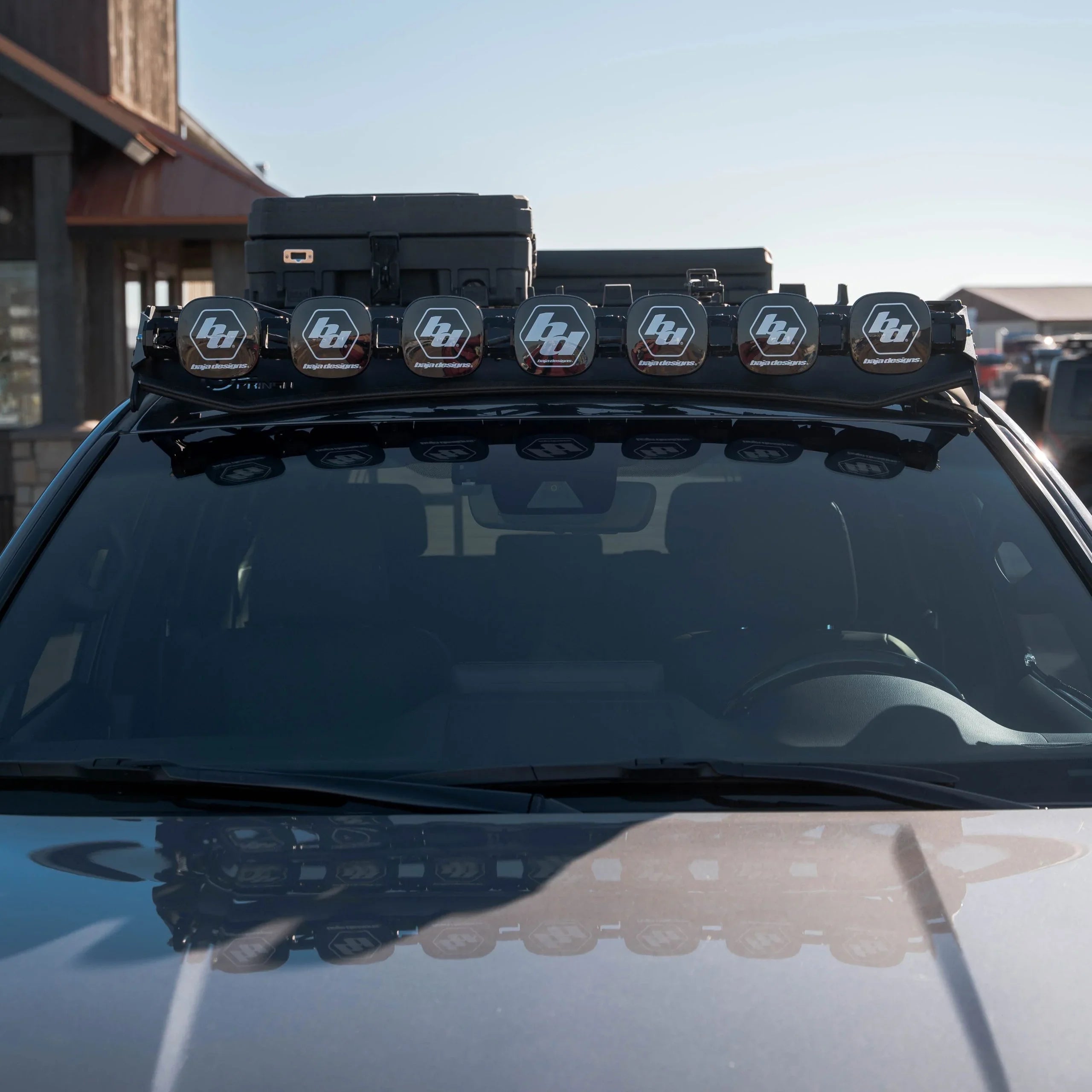 Overland vehicle roof rack with Baja Designs LED light bar and cargo box, front view