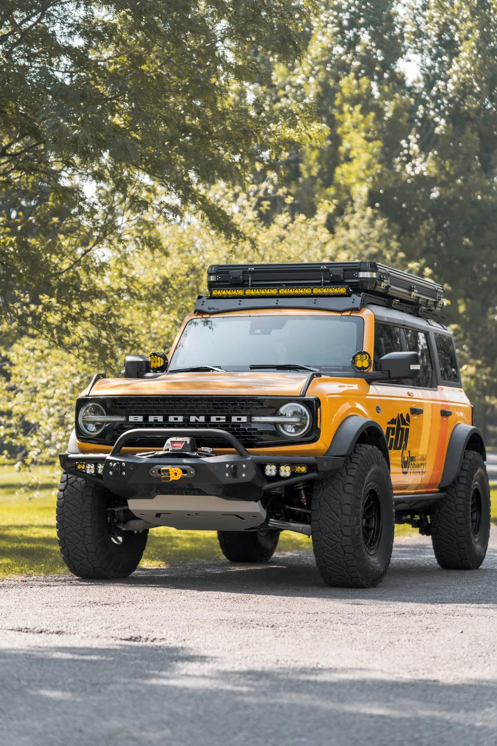 Yellow Ford Bronco with off-road and overlanding accessories parked outdoors