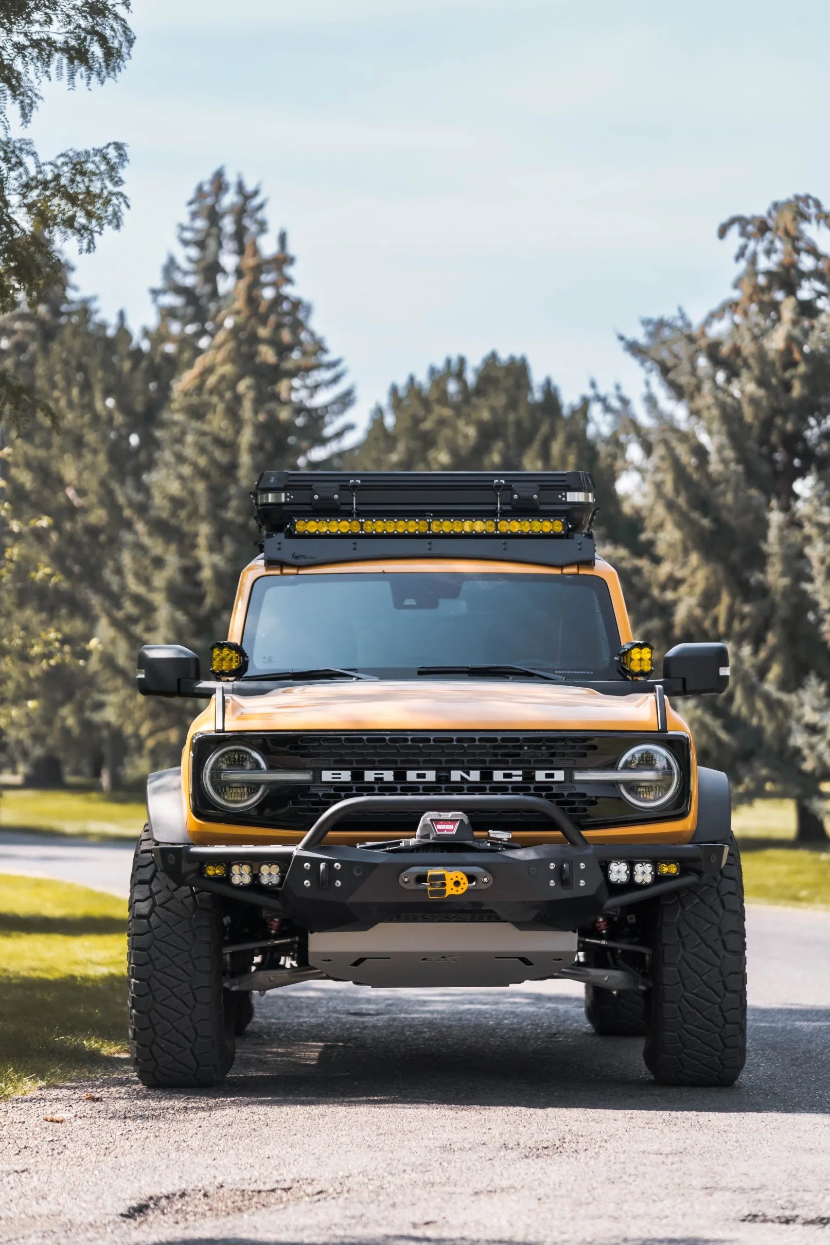 Ford Bronco with off-road accessories, roof rack, and LED lights in outdoor setting