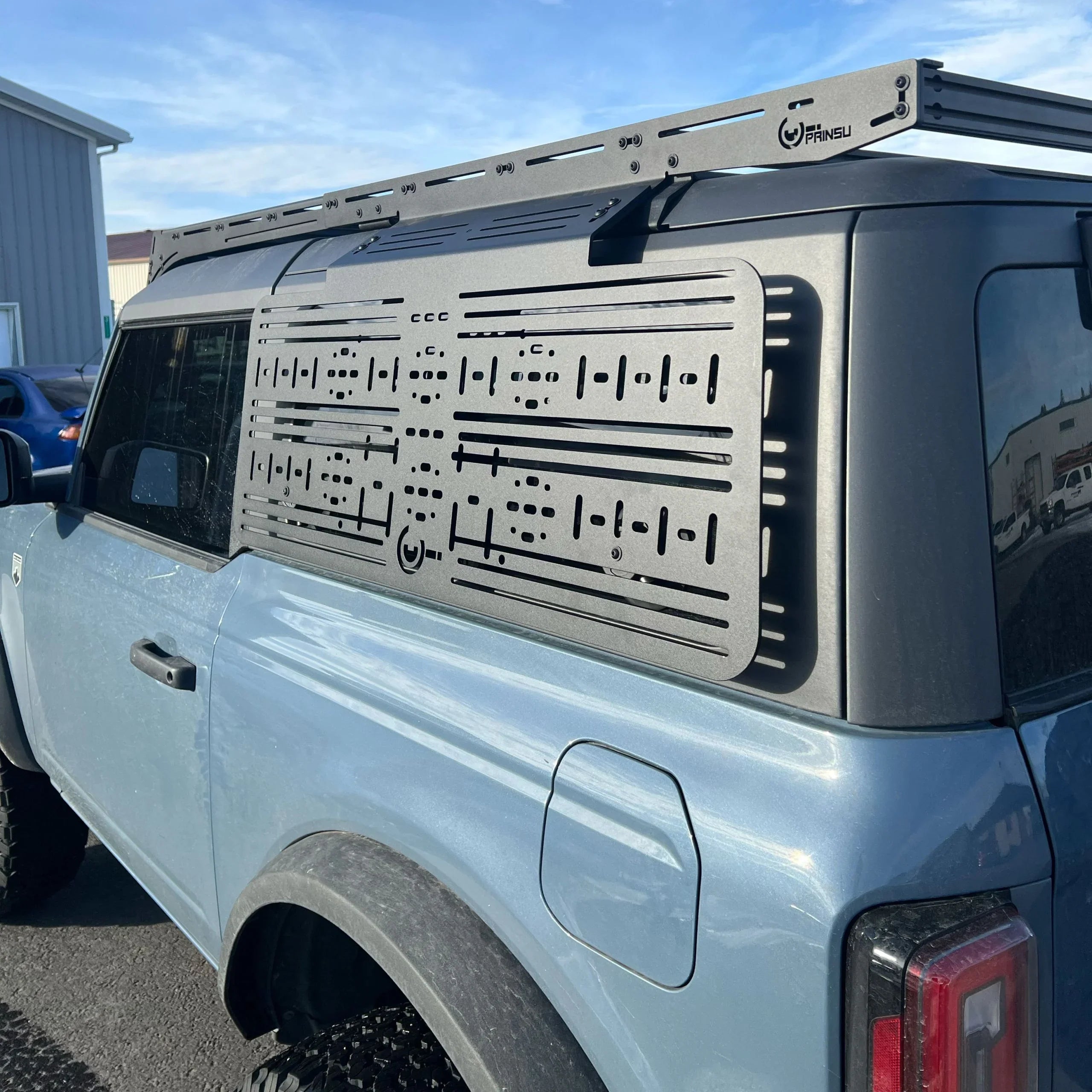 Ford Bronco with black steel molle panel window accessory and roof rack for overlanding