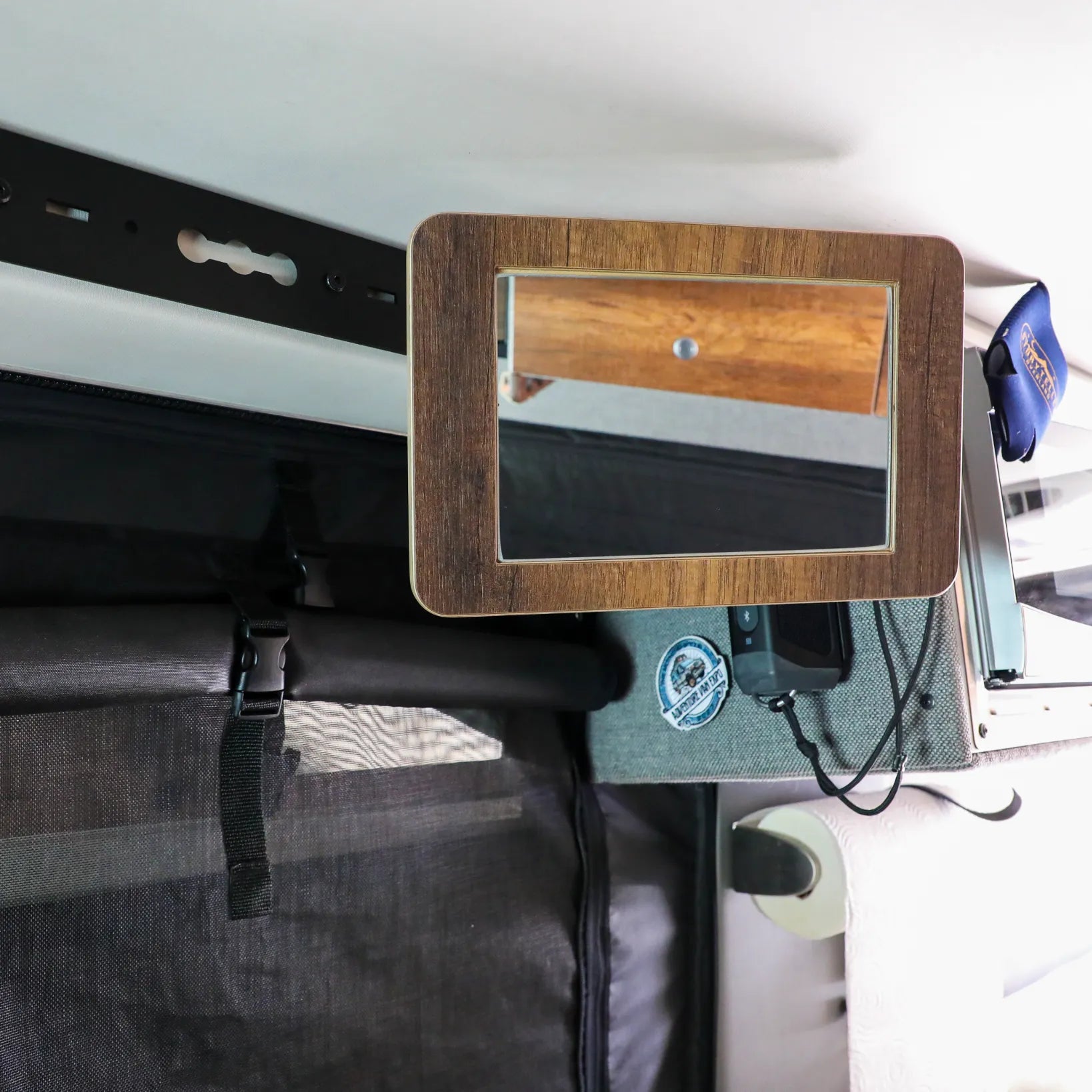 Rectangular wood-framed mirror mounted inside an overlanding vehicle camper setup