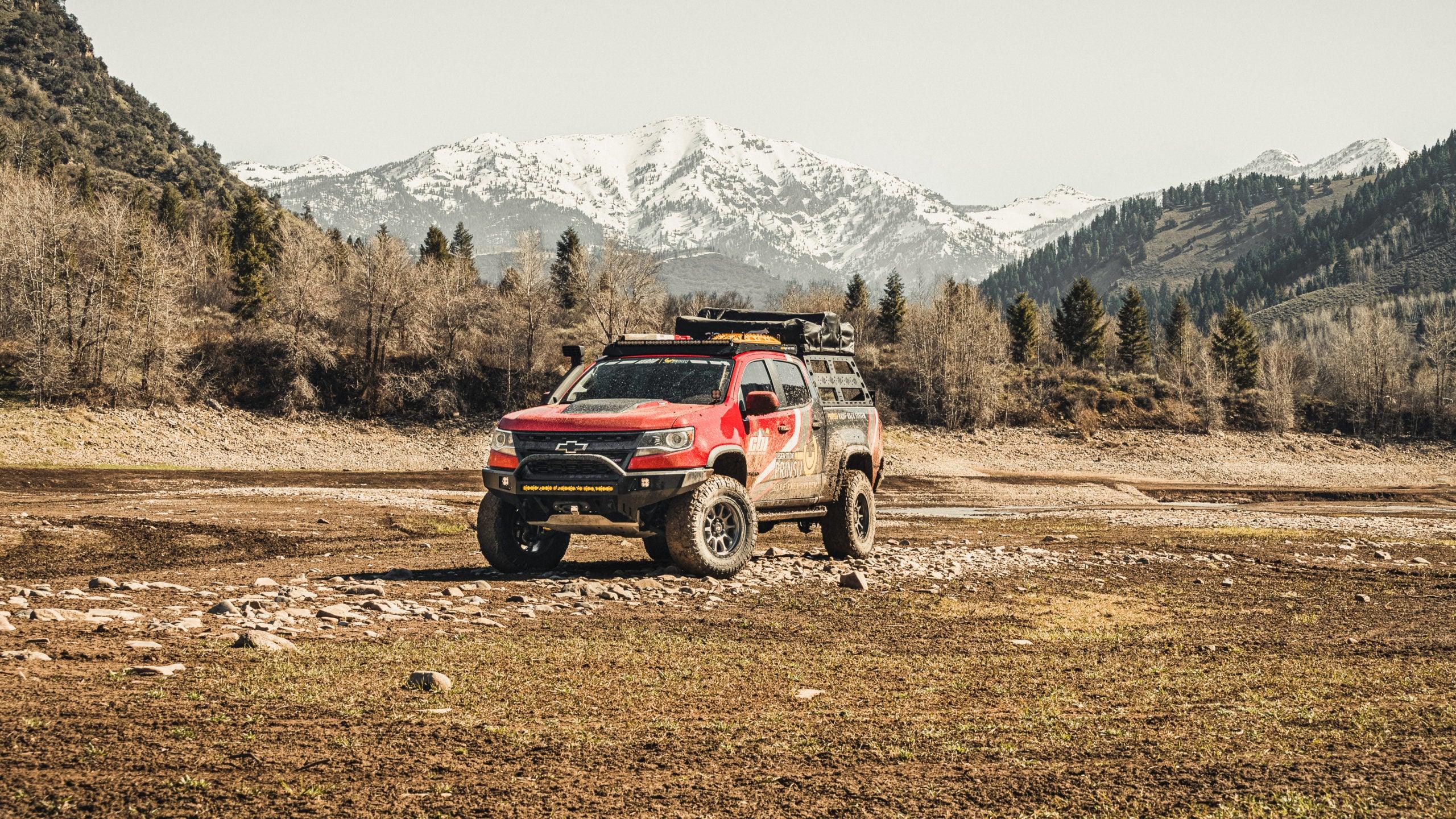 Chevy Colorado ZR2 with off-road bumper parked in rugged terrain, mountains in background