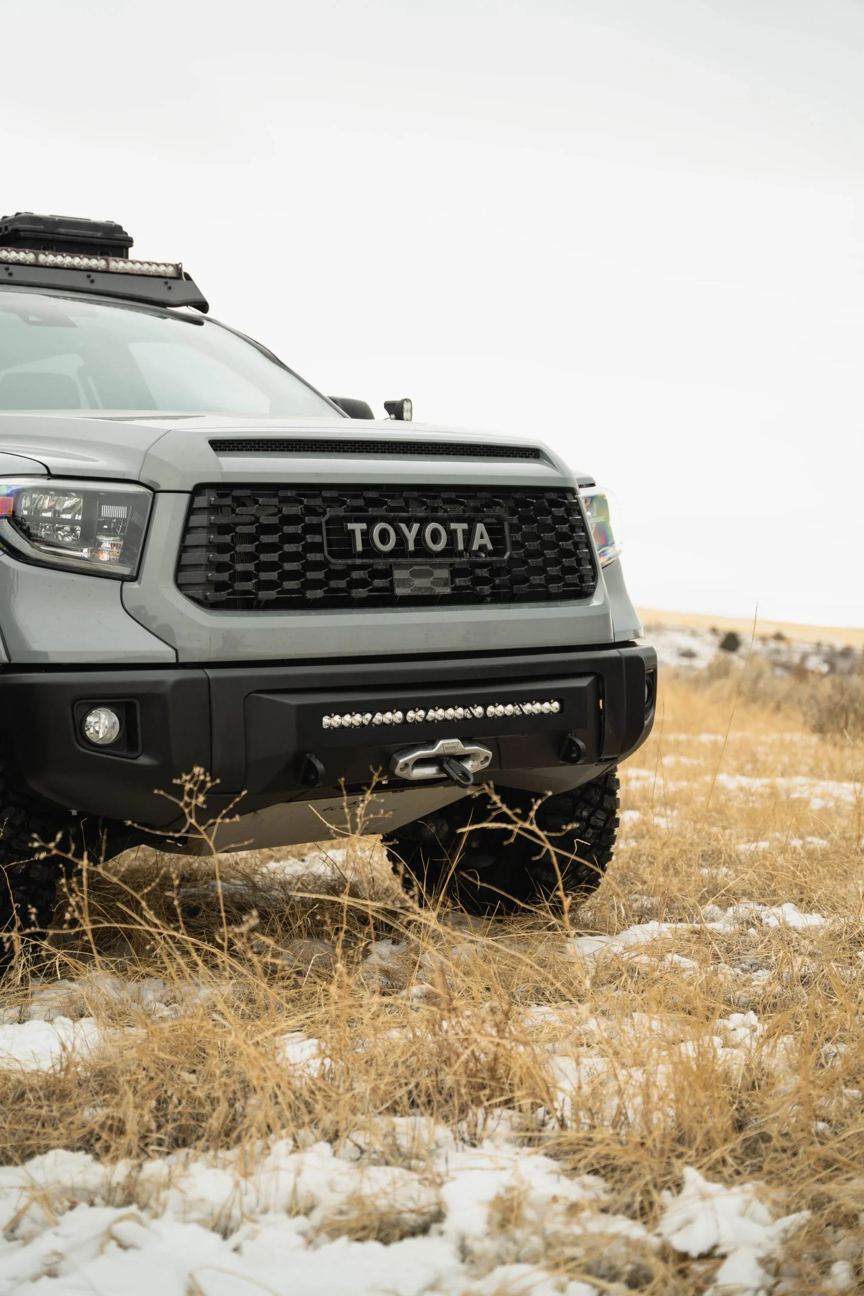 Toyota Tundra with covert front bumper and winch in snowy grass field