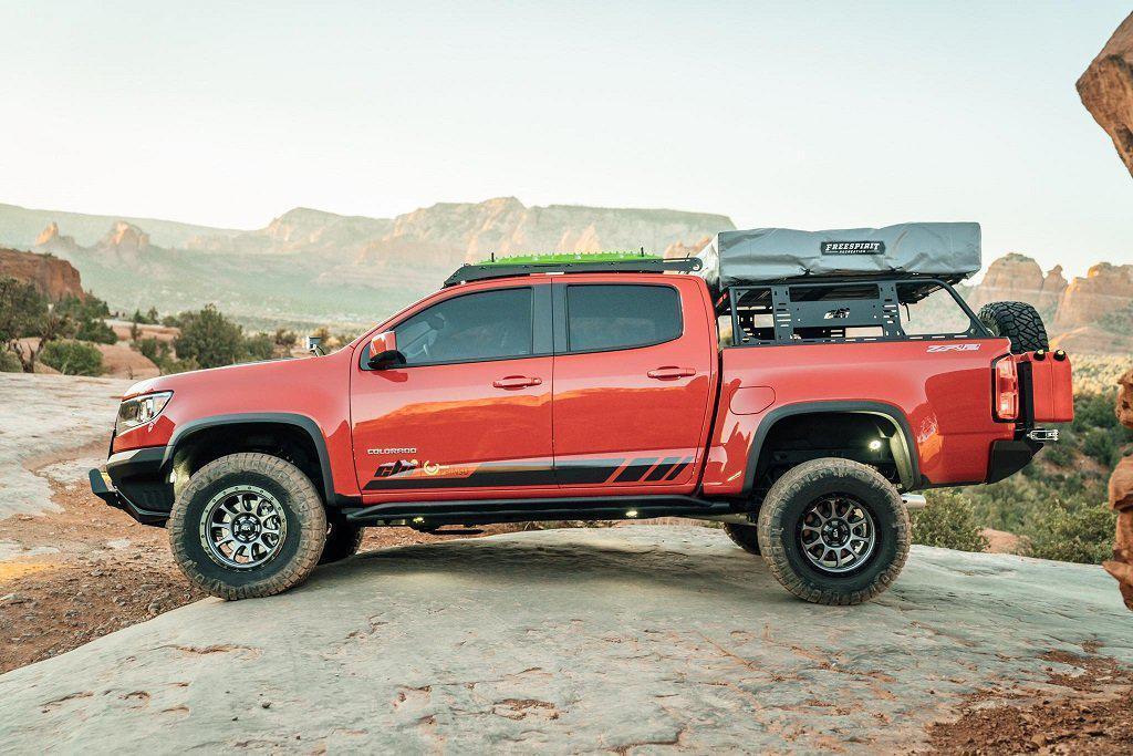 Chevy Colorado overland truck with bed rack, rooftop tent, and off-road gear in desert landscape