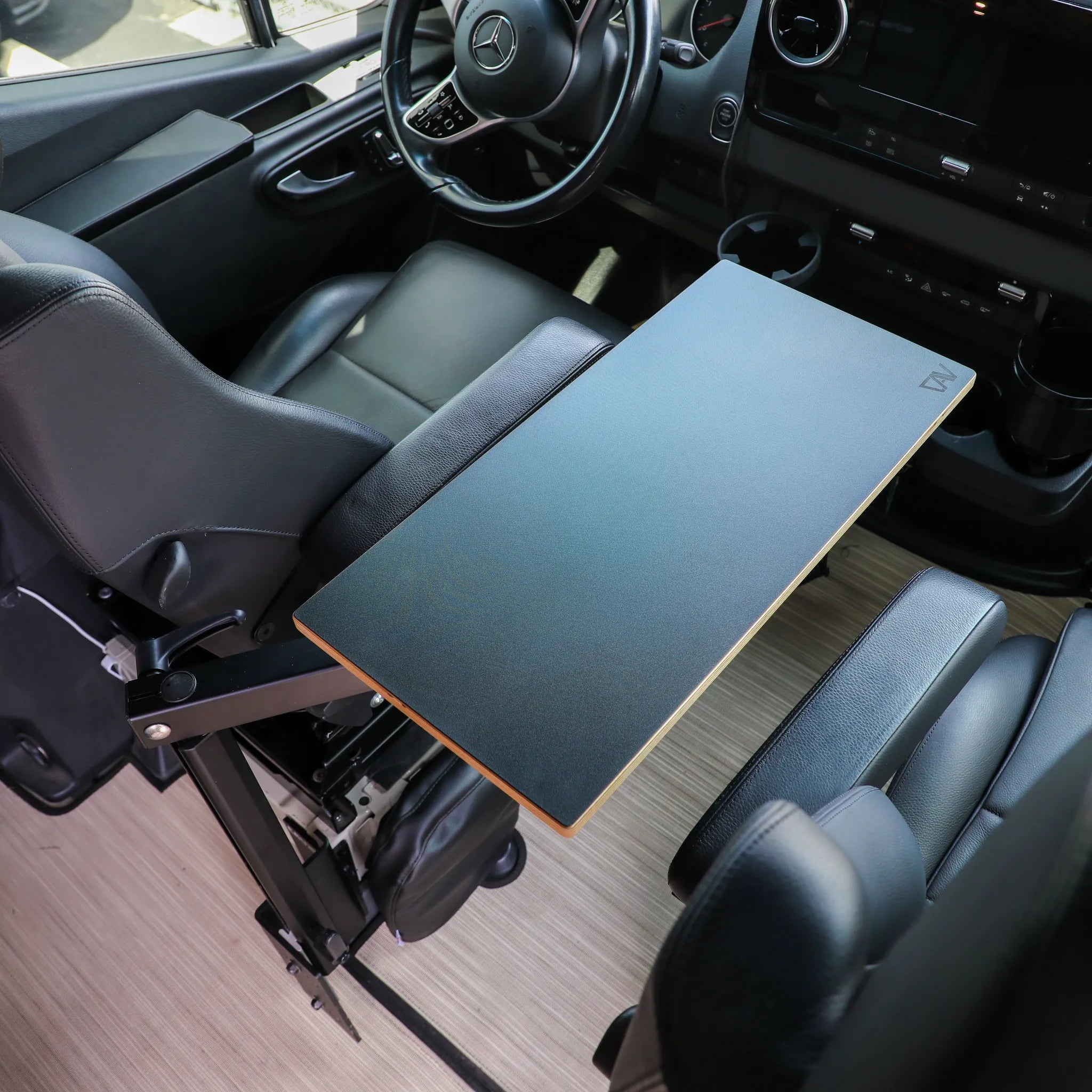 Overland vehicle interior with fold-out console table and black leather seats