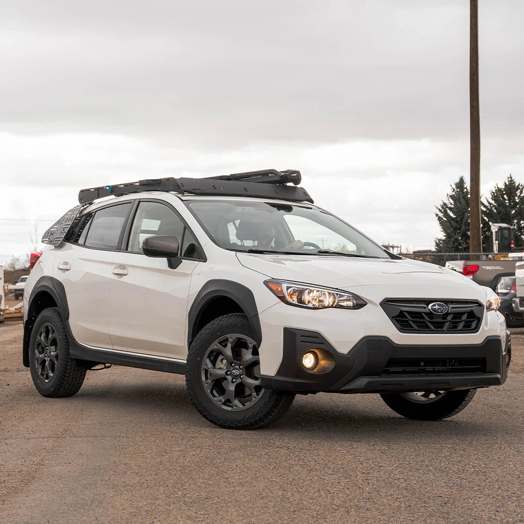White Subaru Crosstrek equipped with overlanding roof rack and off-road accessories