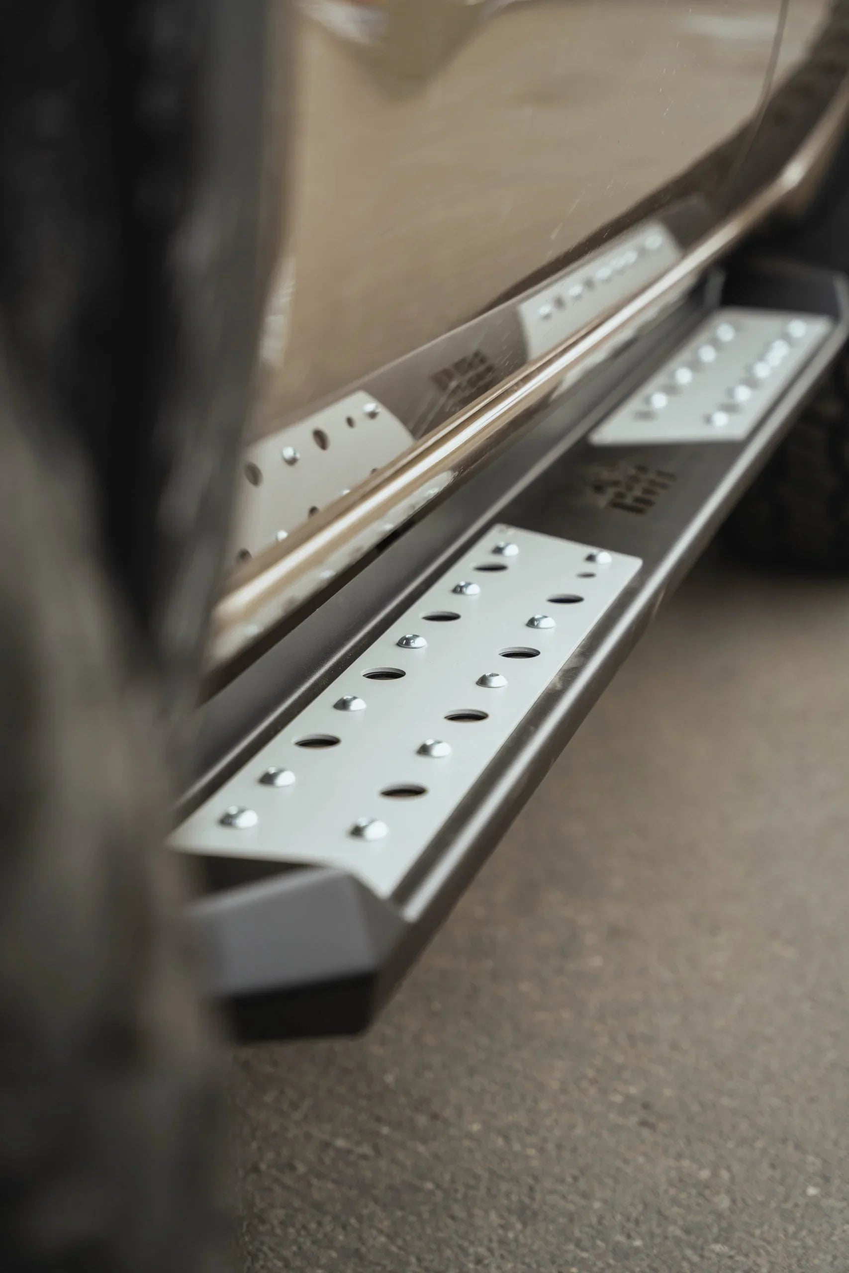 Close-up of rugged steel side step or rock slider on off-road vehicle for overlanding