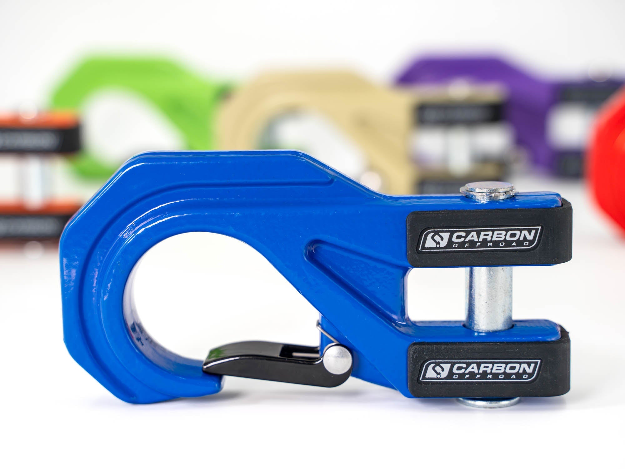 Blue Carbon Offroad recovery hook for overlanding vehicles, with colorful hooks in background