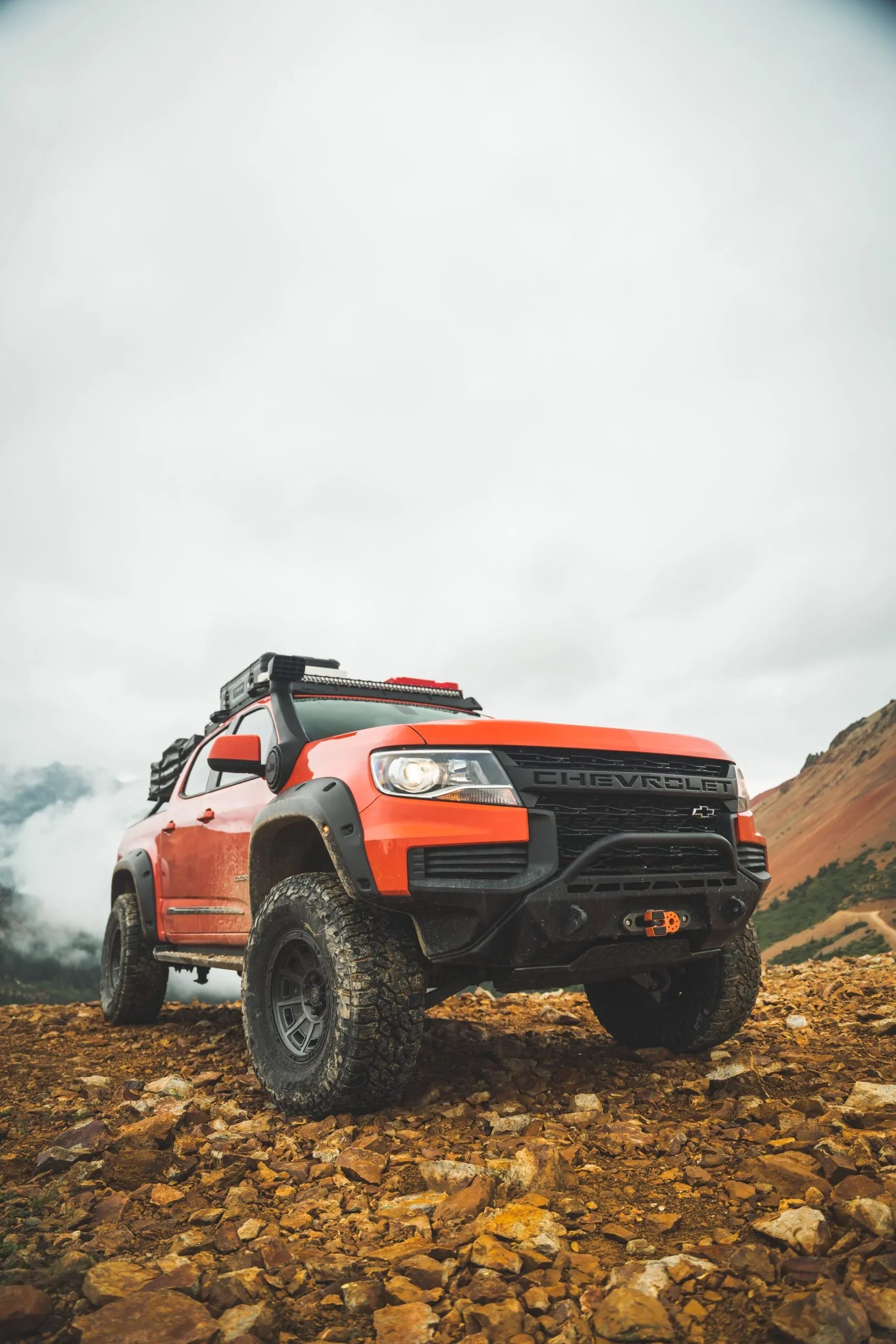 Chevrolet off-road truck with overlanding gear on rocky mountain terrain, outdoor adventure