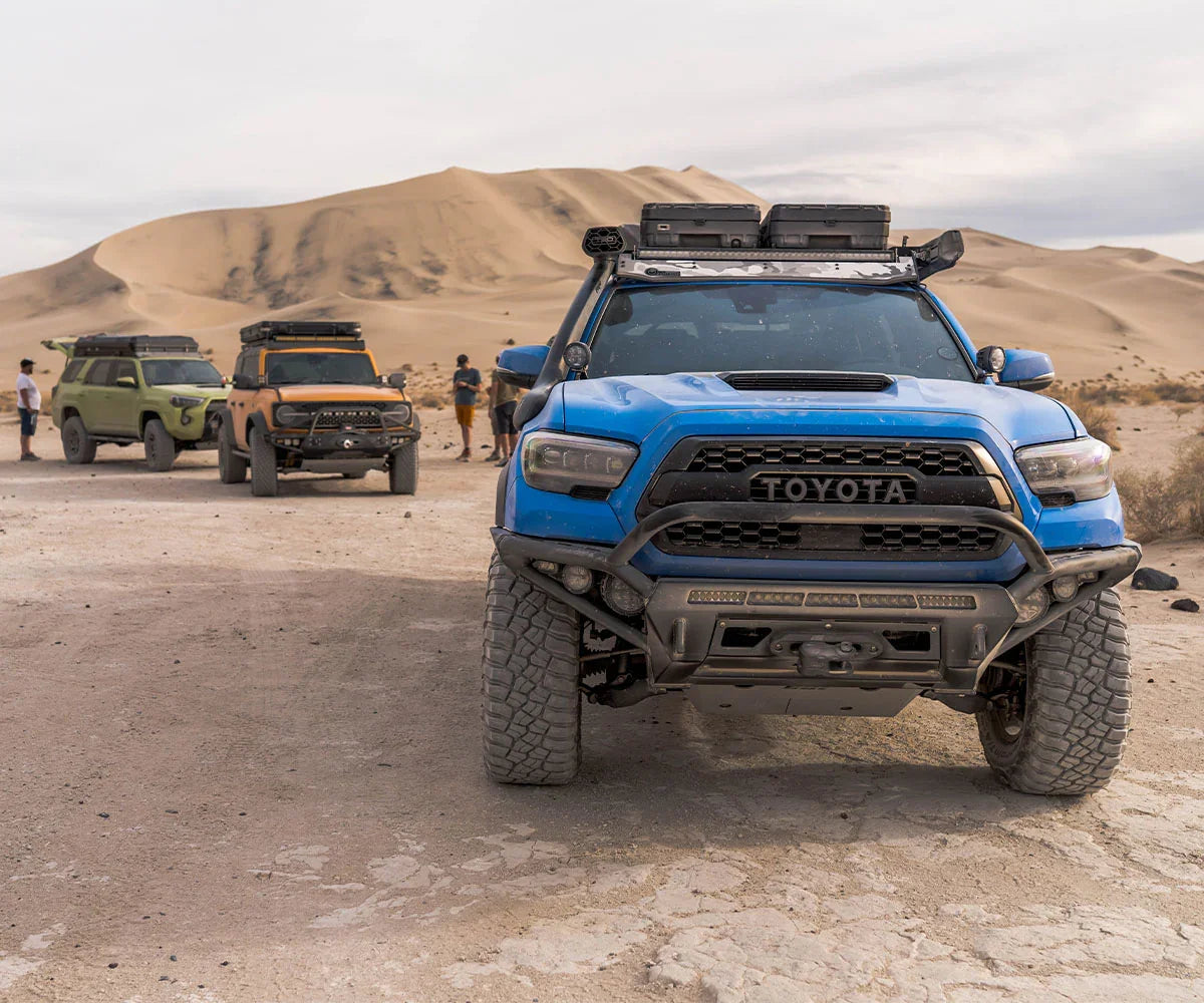 Toyota Tacomas off-roading in Death Valley desert with roof racks and adventure gear