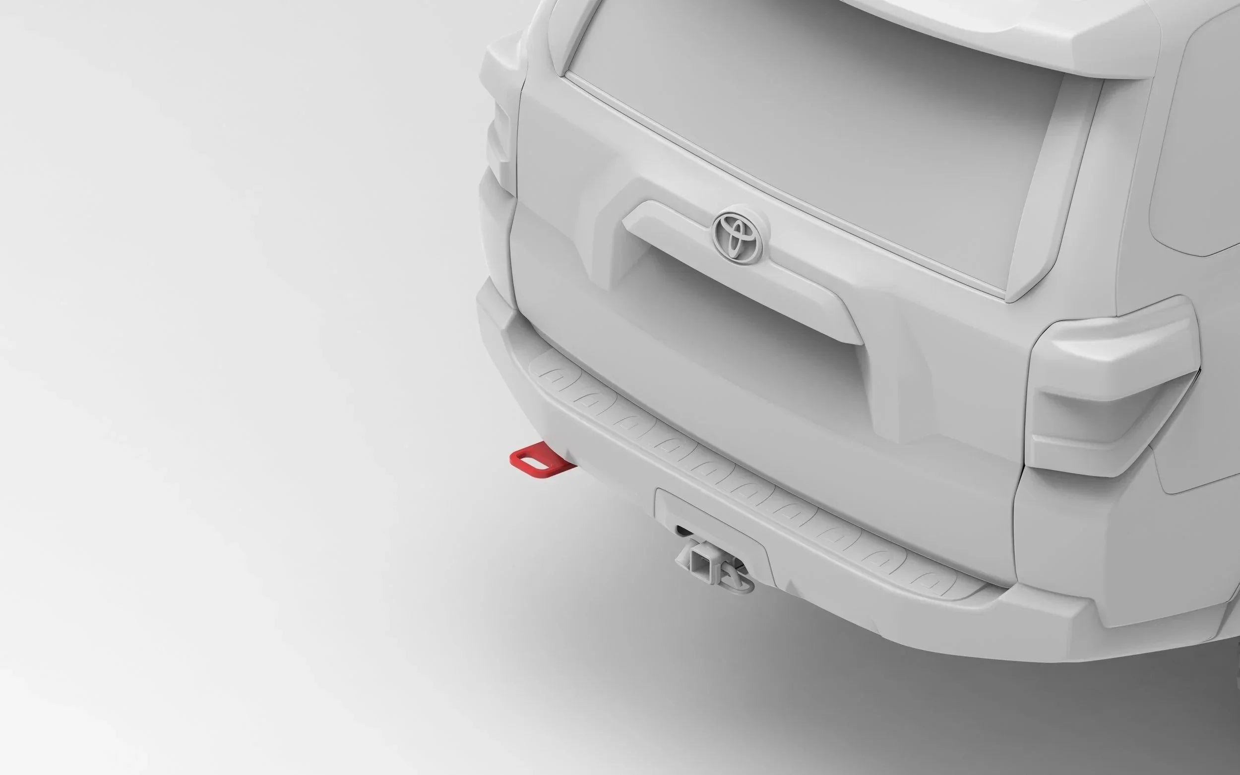 Rear view of a Toyota SUV with a red recovery point and trailer hitch accessory