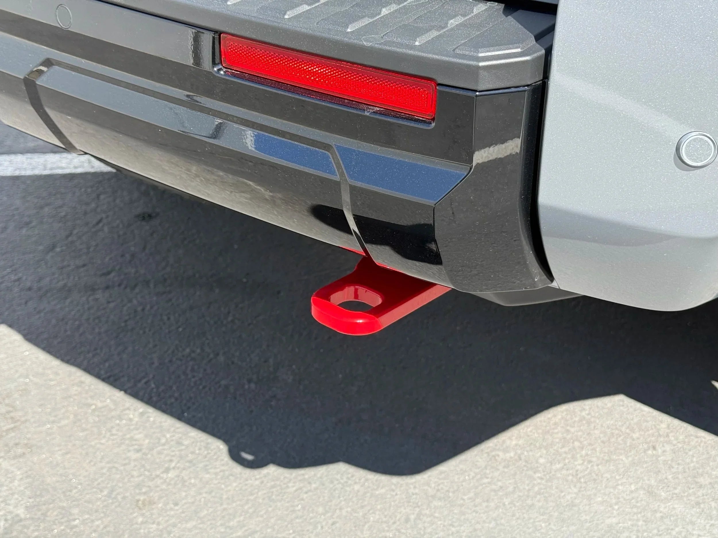 Red rear recovery tow point installed on SUV bumper, suitable for overlanding vehicles