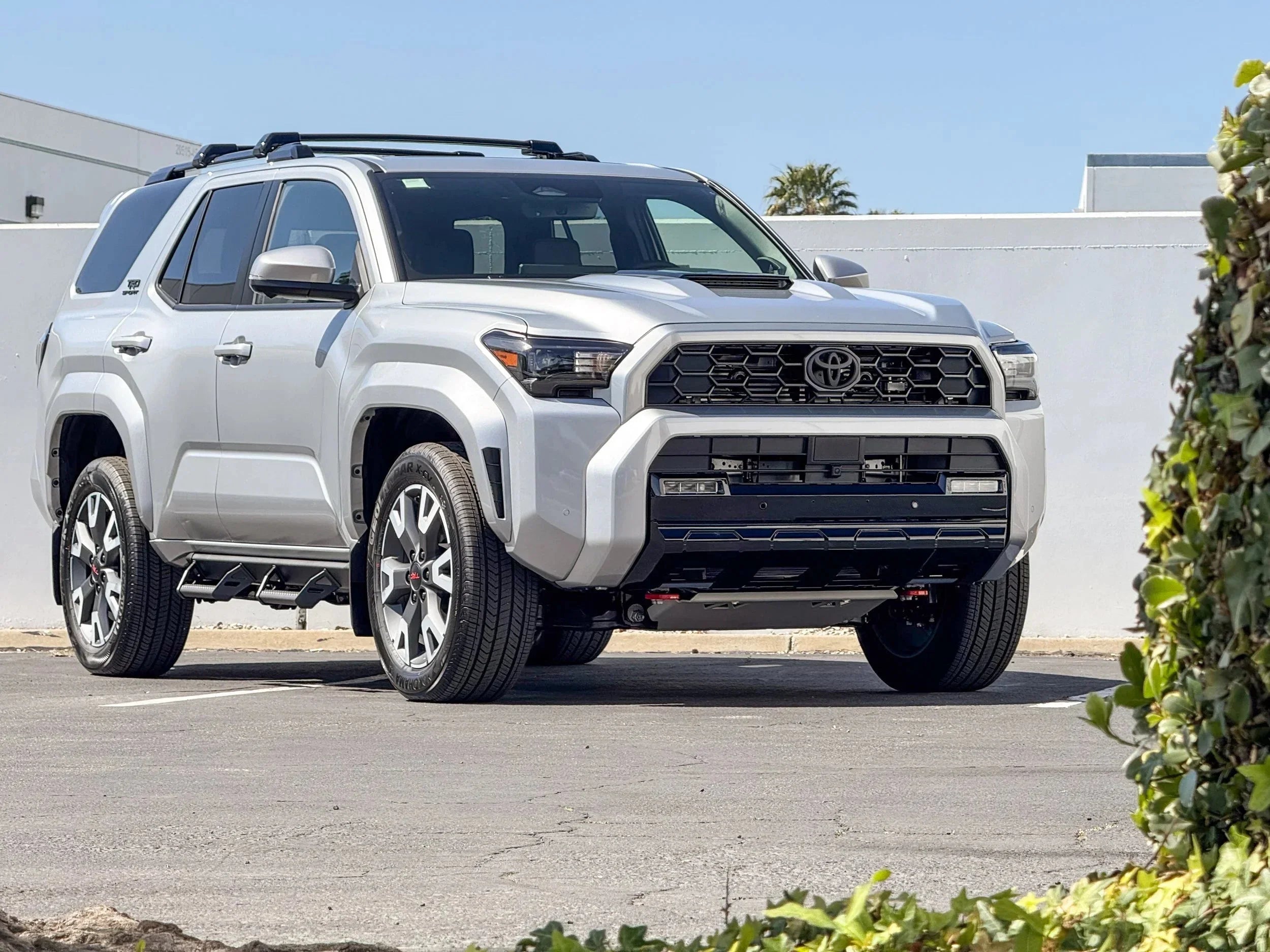 Silver Toyota 4Runner SUV with off-road accessories parked outdoors in daylight.