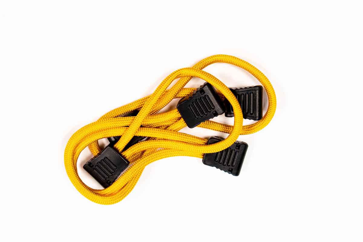 Yellow bungee cord with black plastic hooks for overlanding and camping gear.