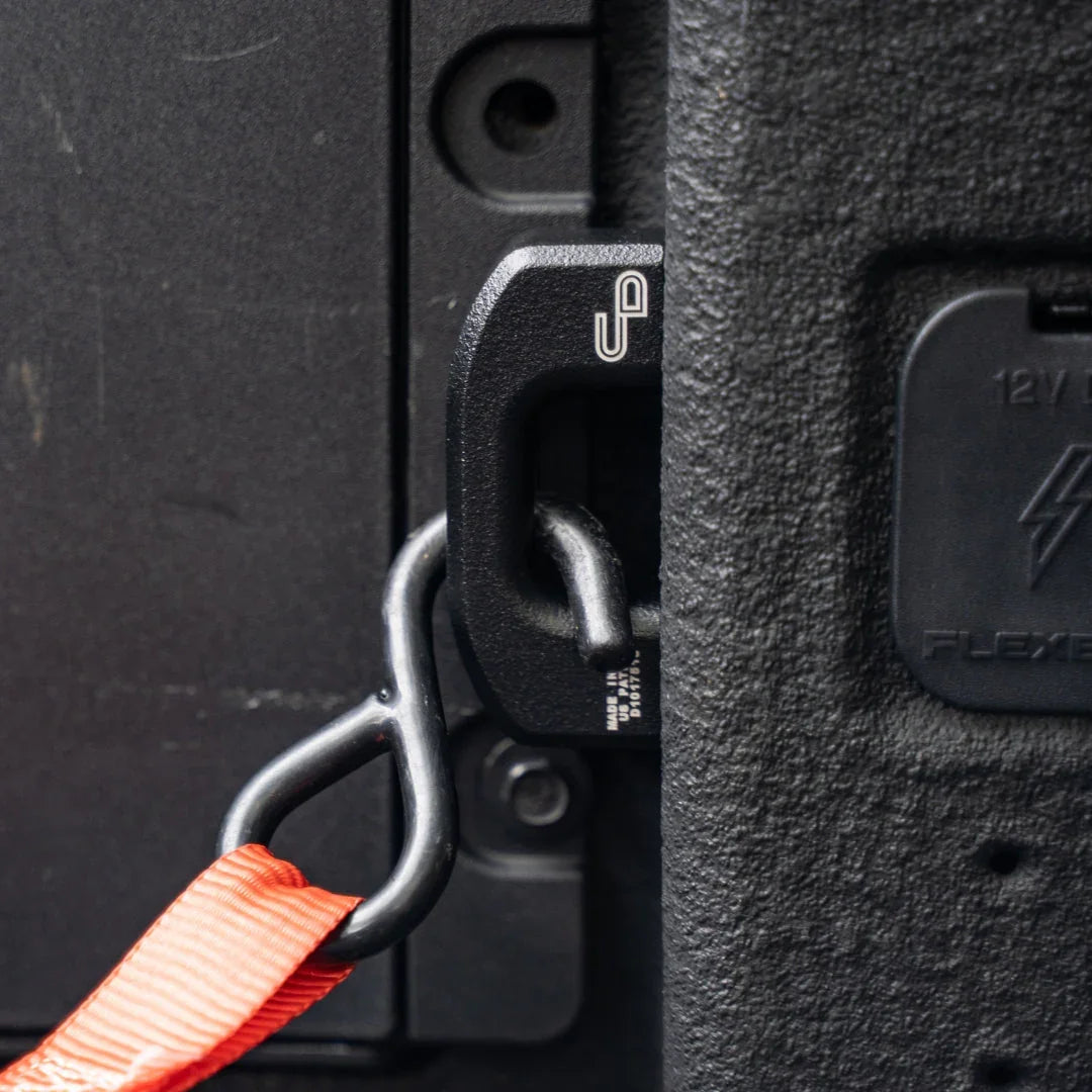 Black powder coated bed tie down in Ford Maverick truck with orange strap attached