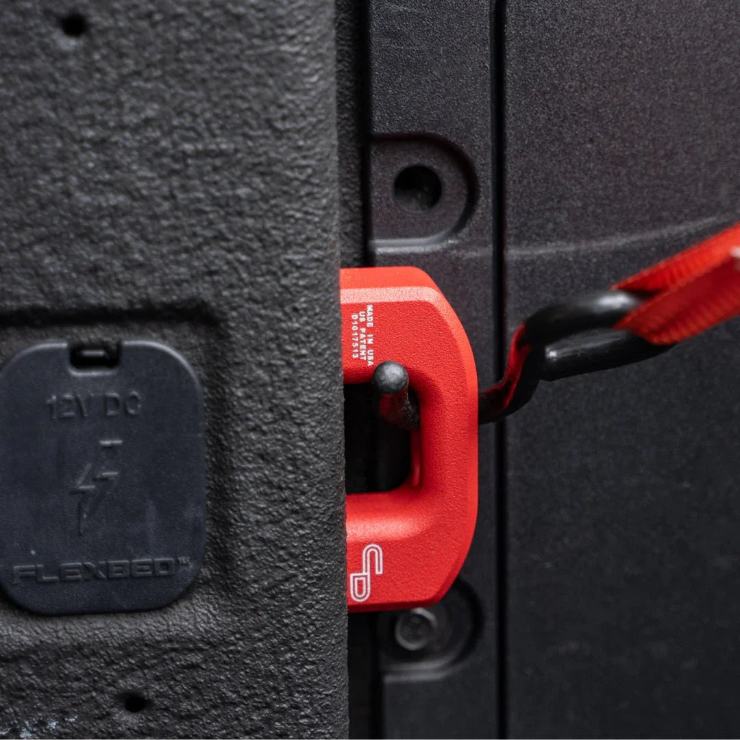 Ford Maverick truck bed with red powder coated tie down anchor and cargo strap