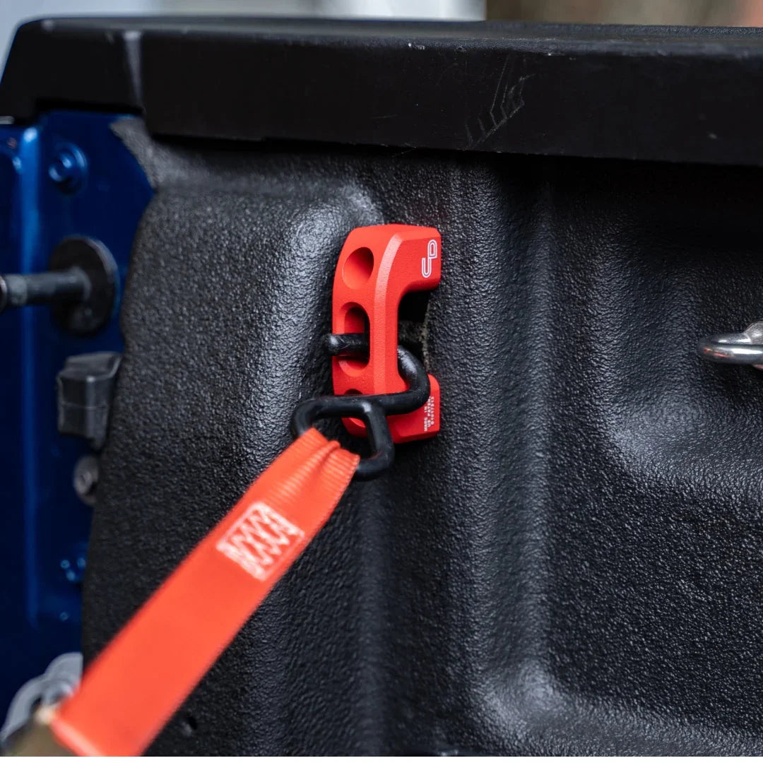 Red powder coated metal bed tie down installed in a Ford Maverick truck bed