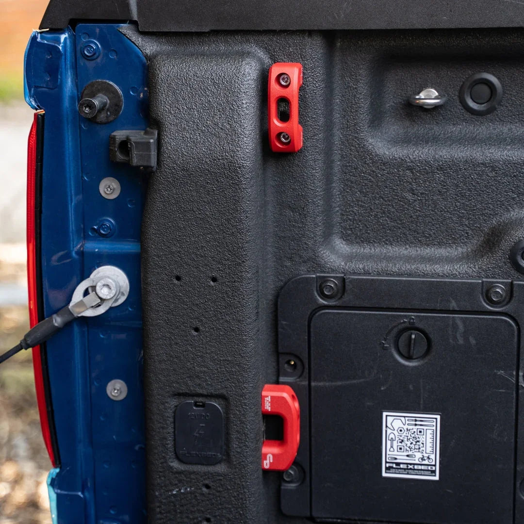 Ford Maverick truck bed with red powder-coated tie down anchors installed