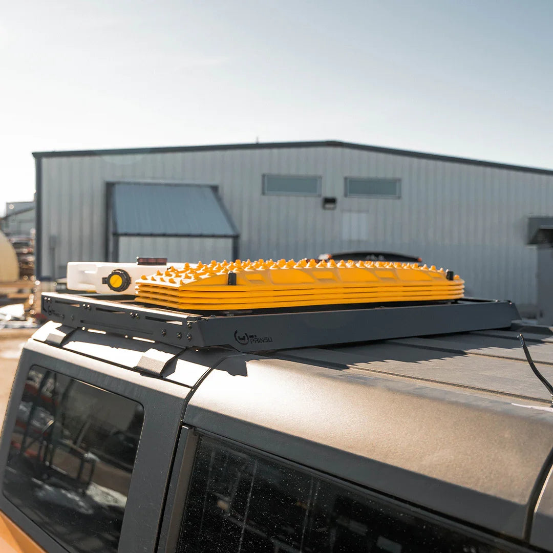 Ford Bronco roof rack with yellow traction boards and off-road gear mounted on top