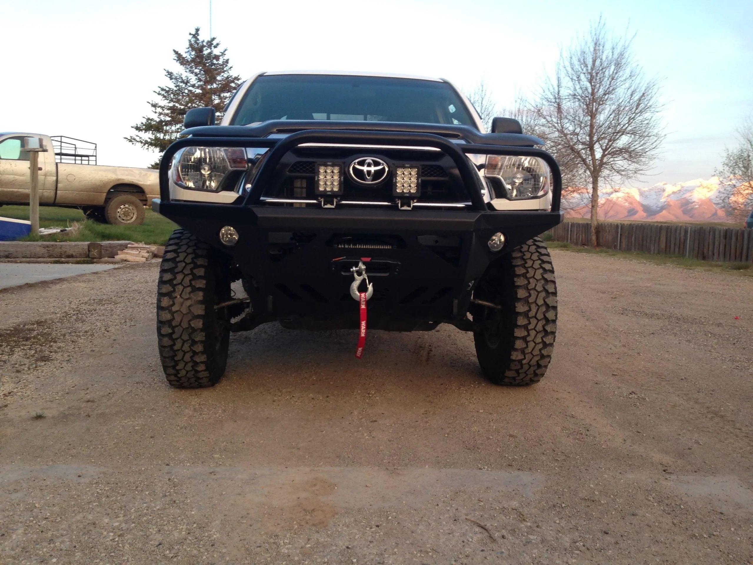Toyota Tacoma with off-road front bumper and LED lights, parked outdoors