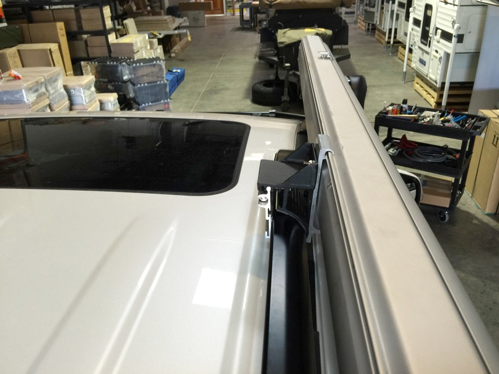 Heavy-duty G clamp with S 2000 mount securing an awning to a vehicle roof rack in a workshop