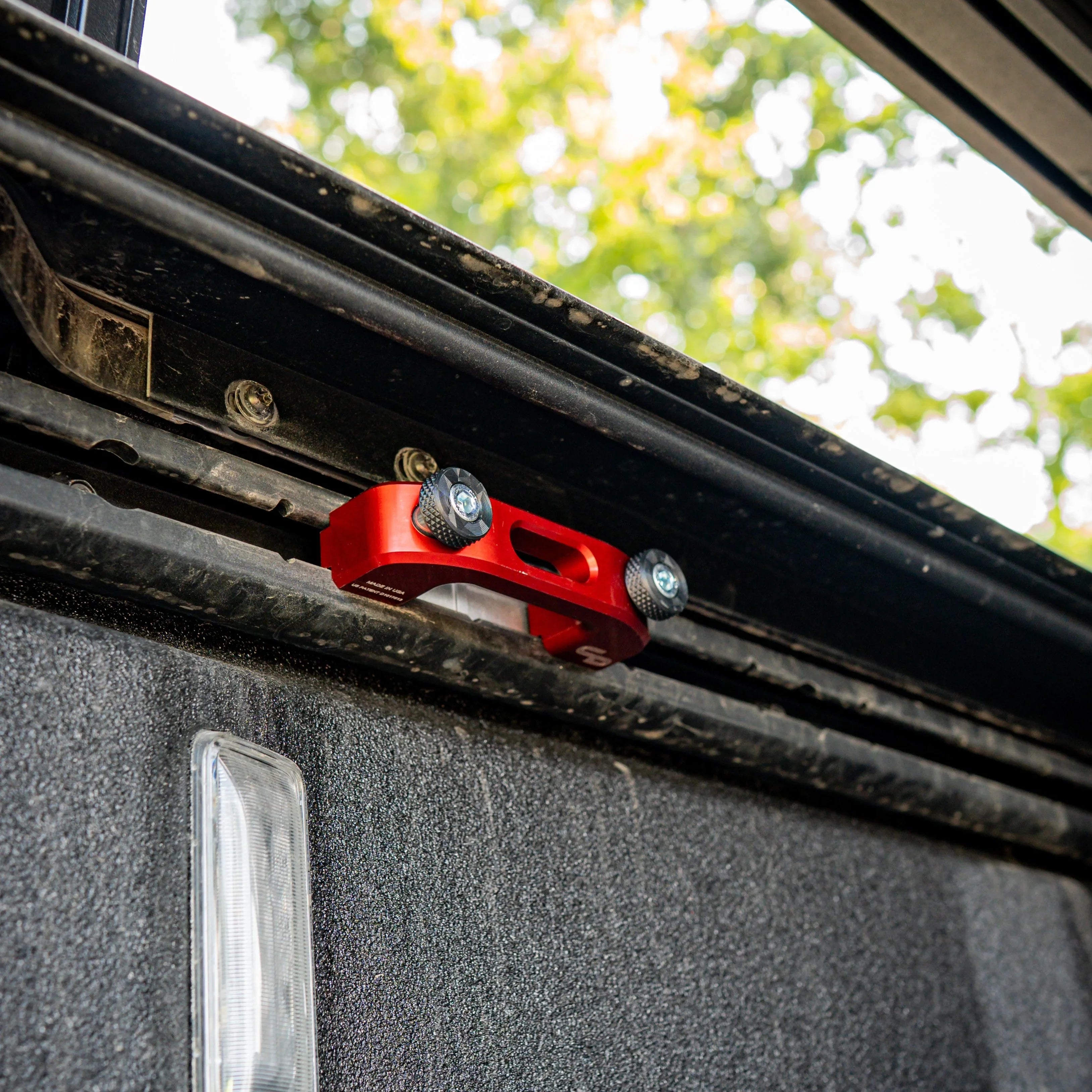 Red billet rail tie down with speed knobs installed on truck bed rail