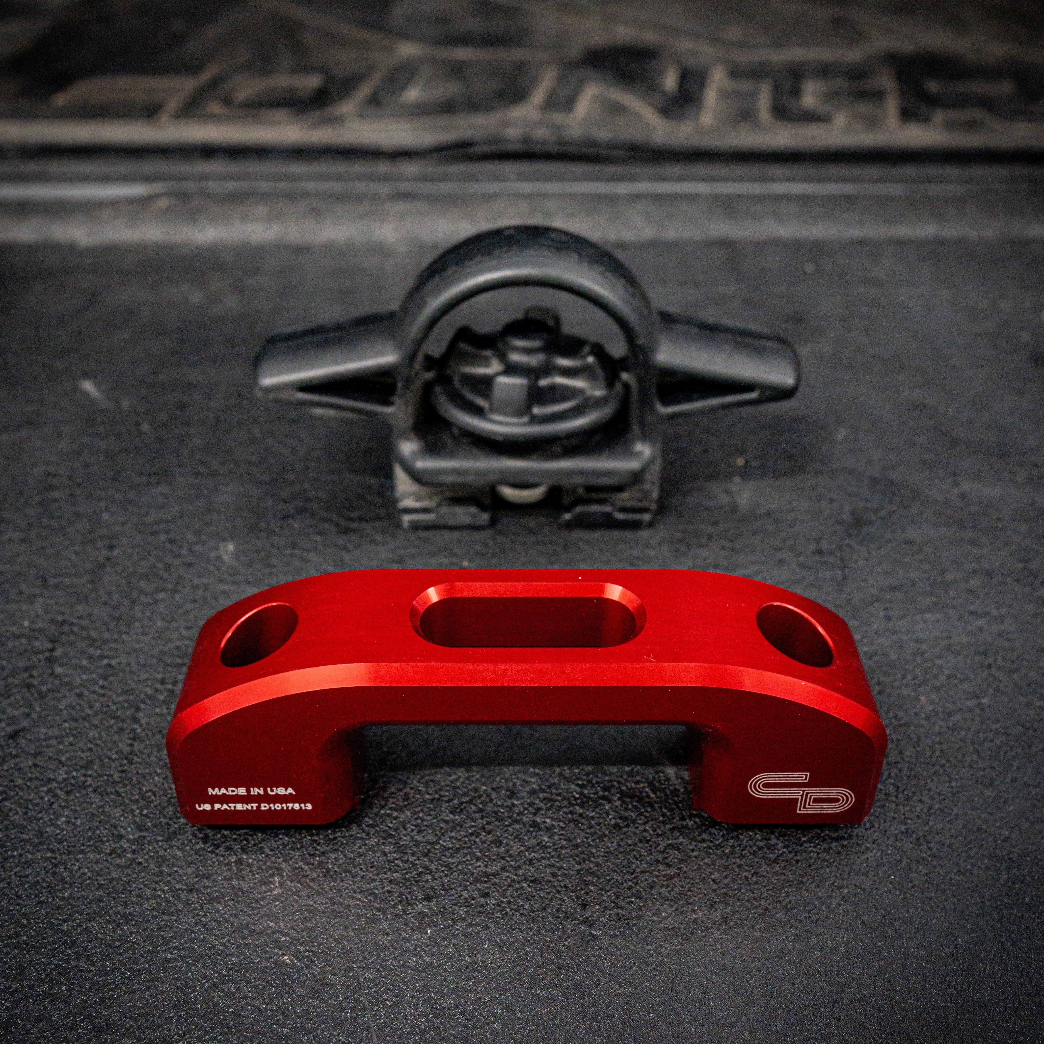 Red billet rail tie down and black stock tie down on truck bed liner