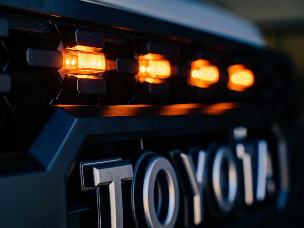 Close-up of Toyota grille with amber LED marker lights for off-road vehicle accessories