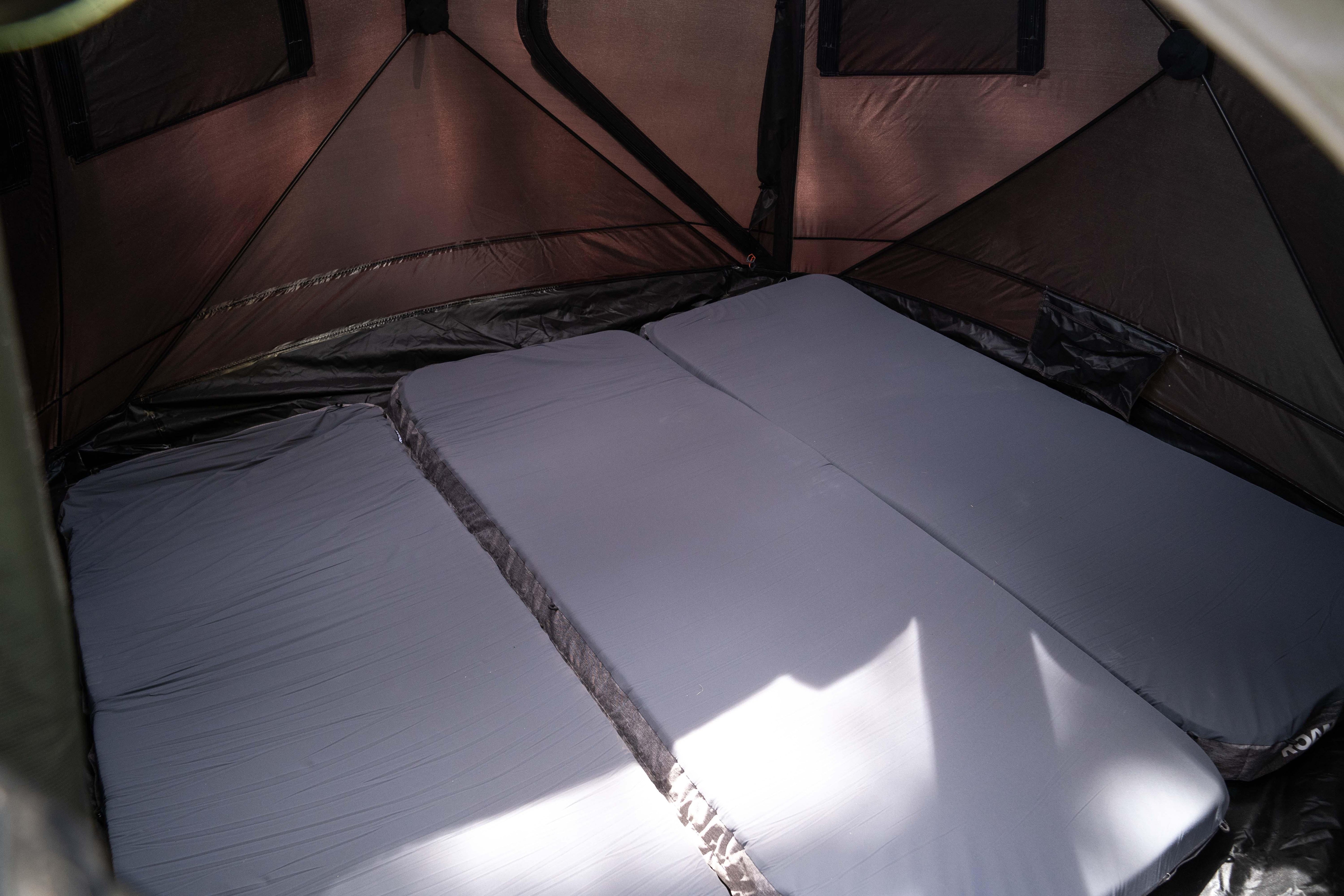 Interior of camping tent with three gray sleeping pads for overlanding and expedition gear