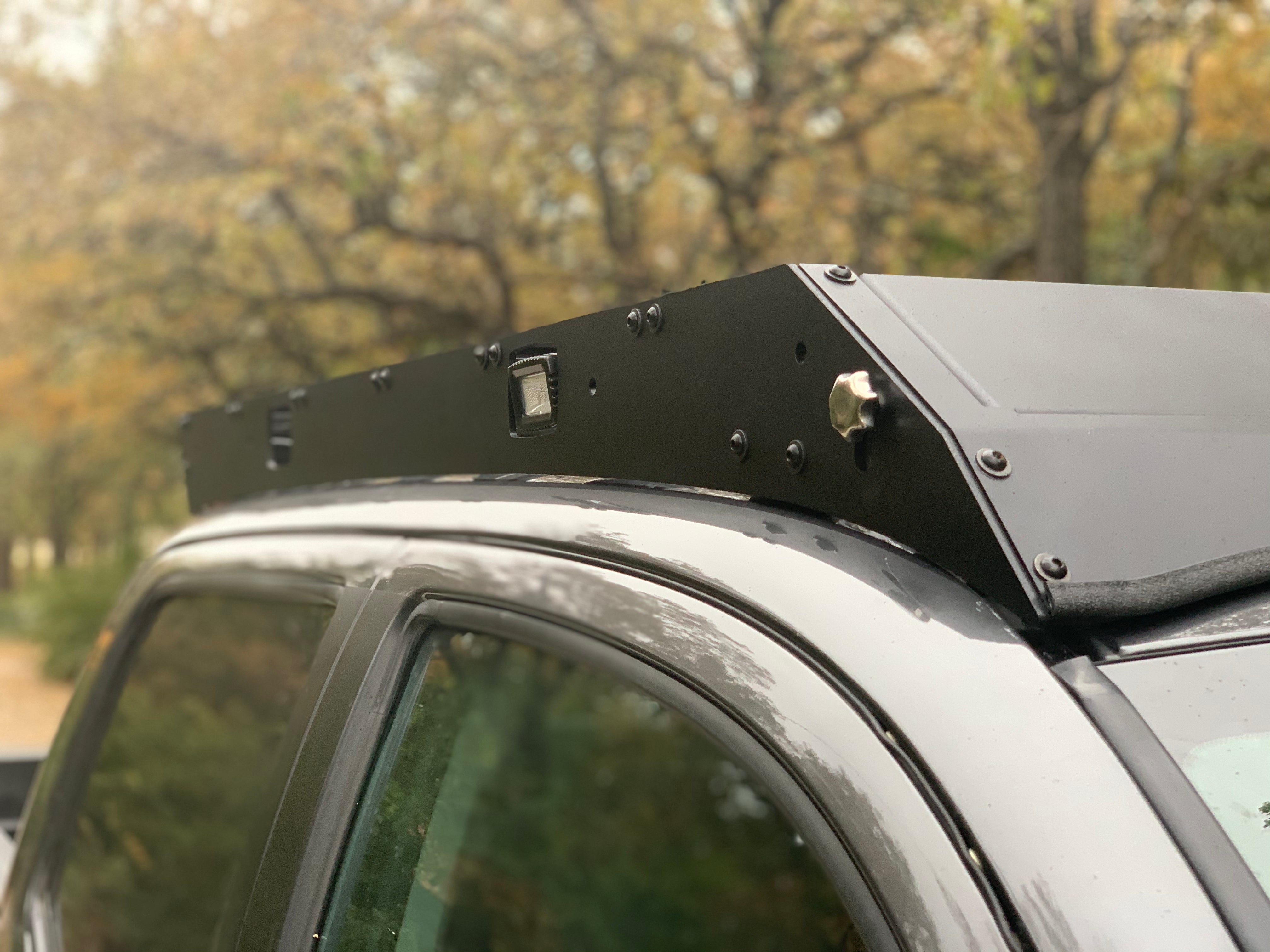 Black metal roof rack installed on an off-road vehicle in an outdoor setting