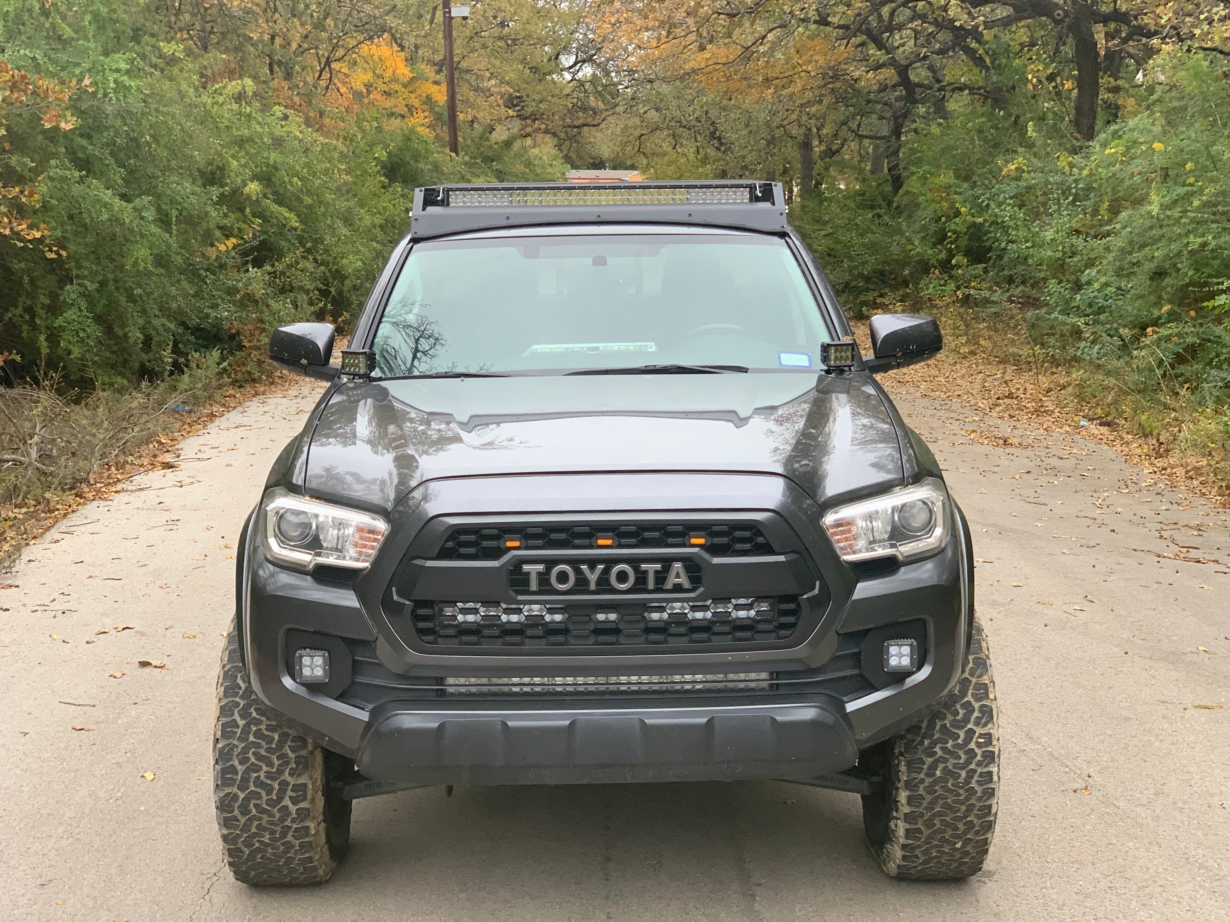 Toyota Tacoma with off-road accessories and LED lights on forest road