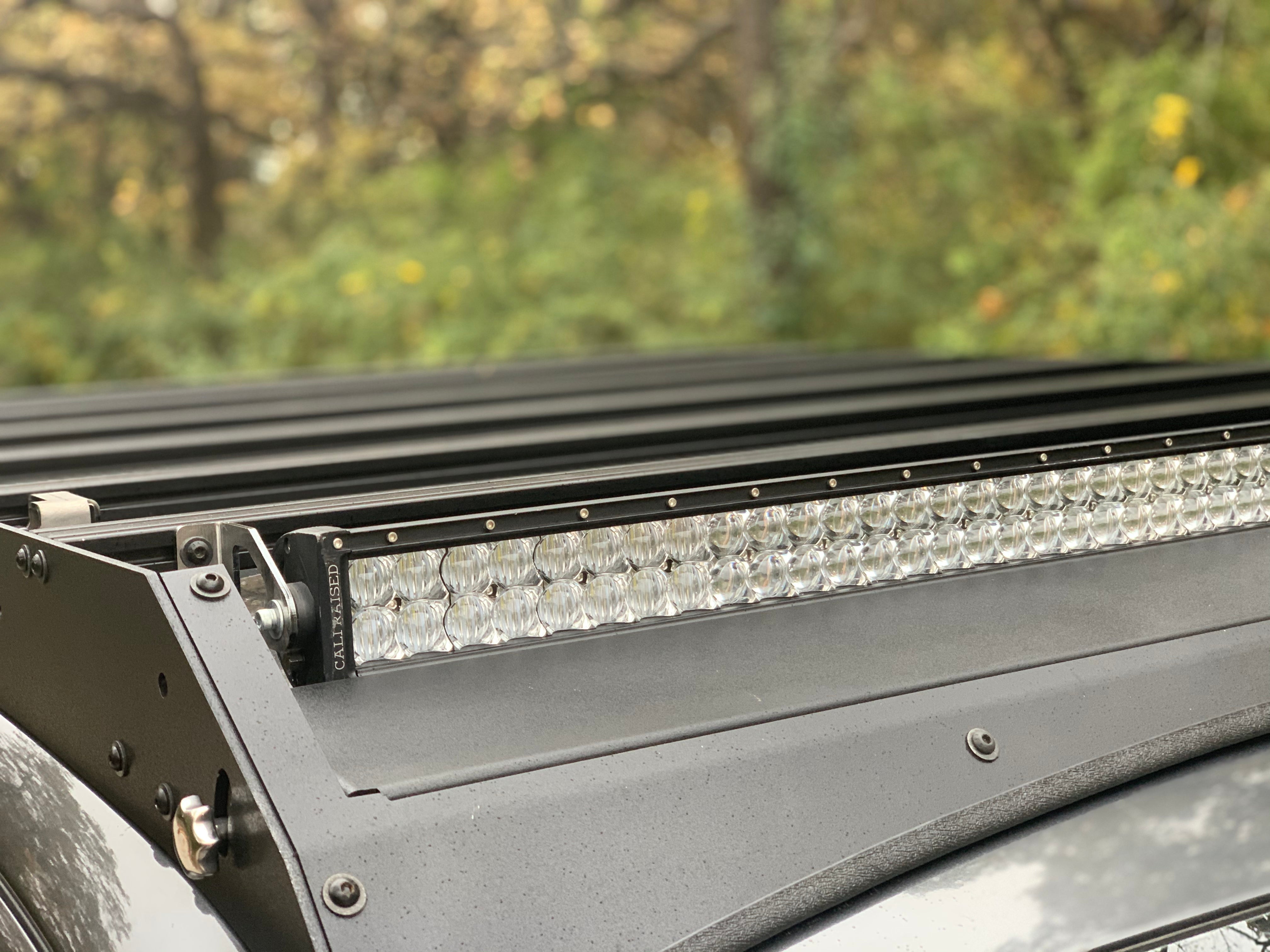 Close-up of vehicle roof rack with mounted LED light bar for overlanding and expedition use