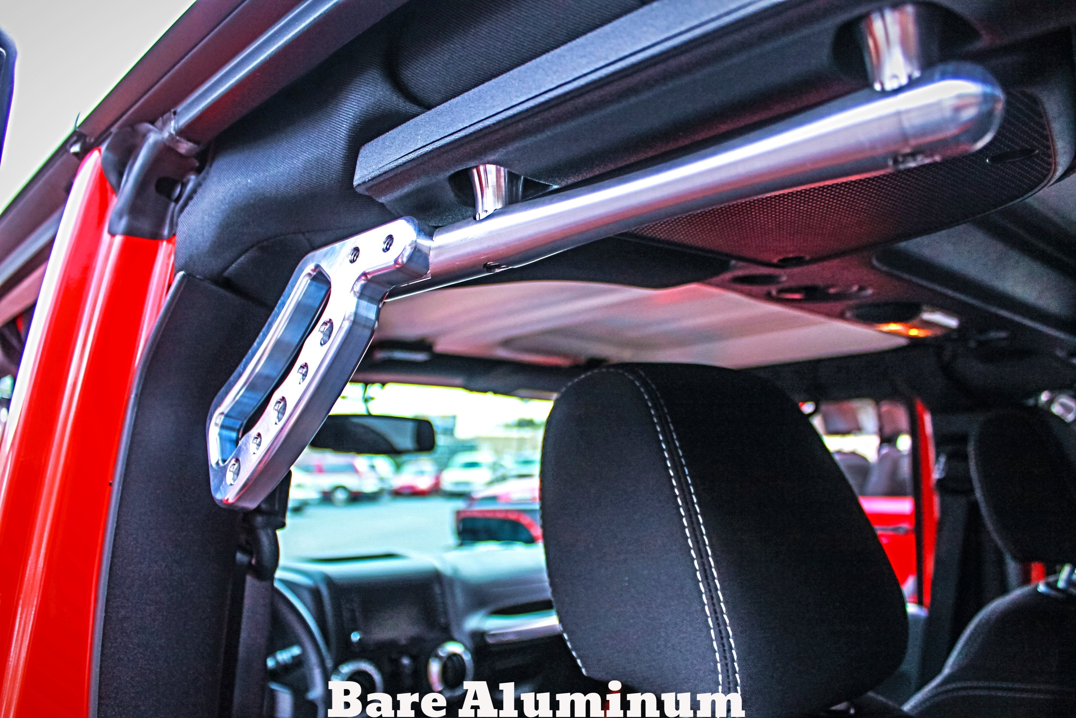 Bare aluminum grab handle installed on interior roll bar of an off-road vehicle