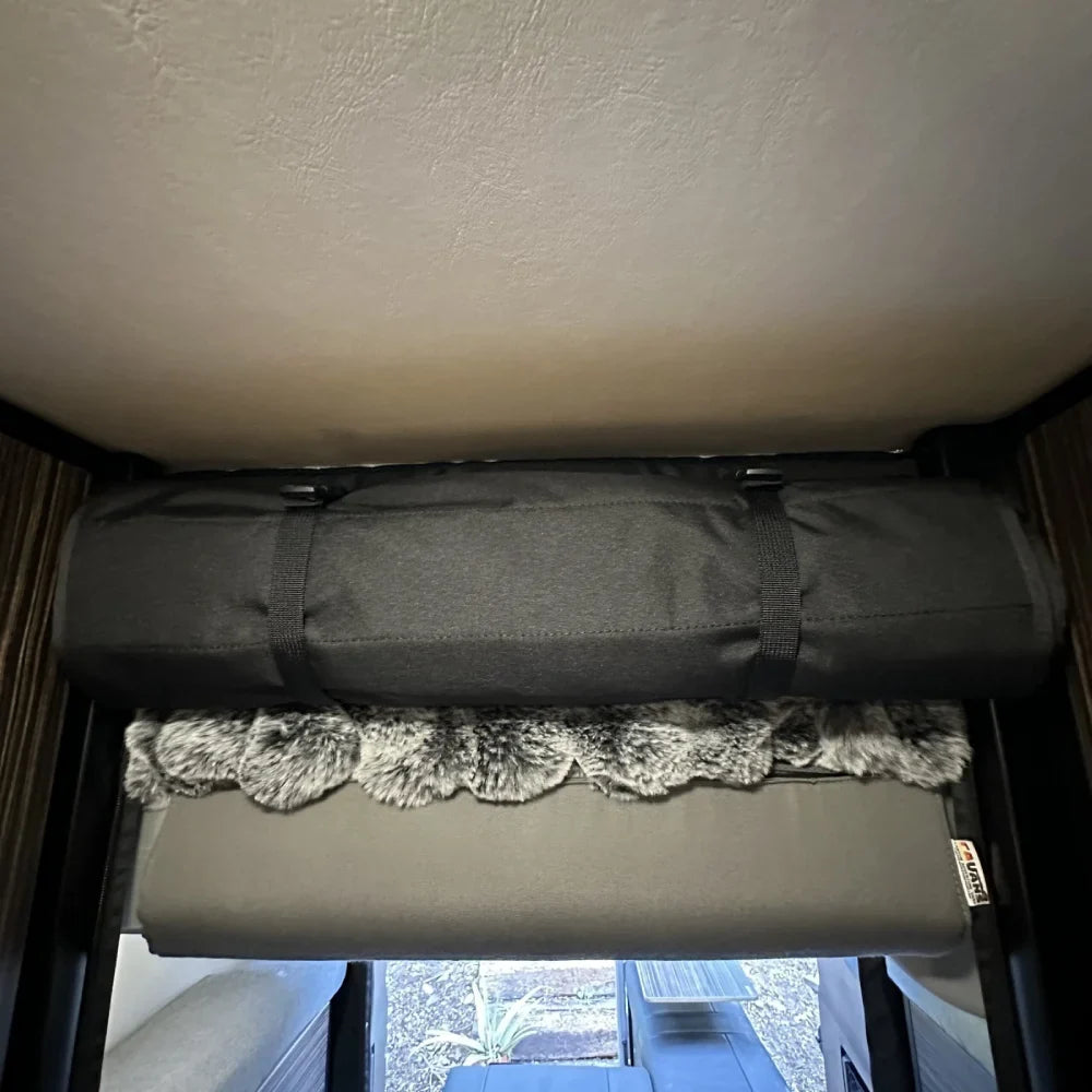 Black rooftop tent mattress and bedding with storage bag in overland vehicle interior