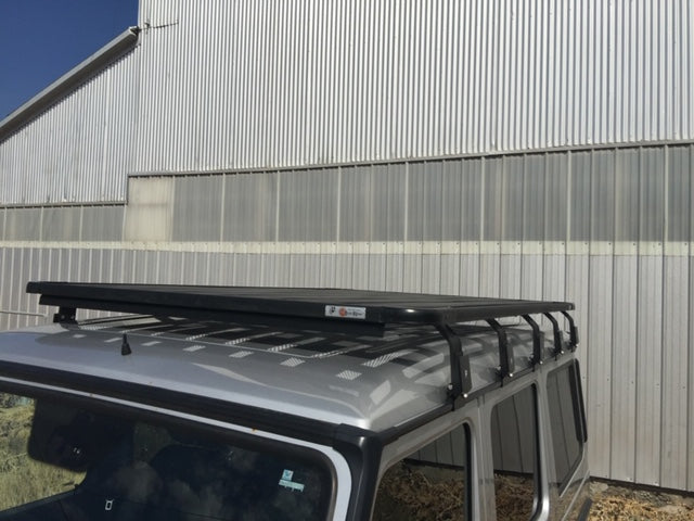 Black roof rack mounted on silver overlanding SUV, outdoor adventure accessory