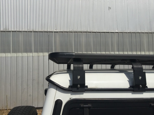 Heavy-duty roof rack installed on a white off-road vehicle, industrial background