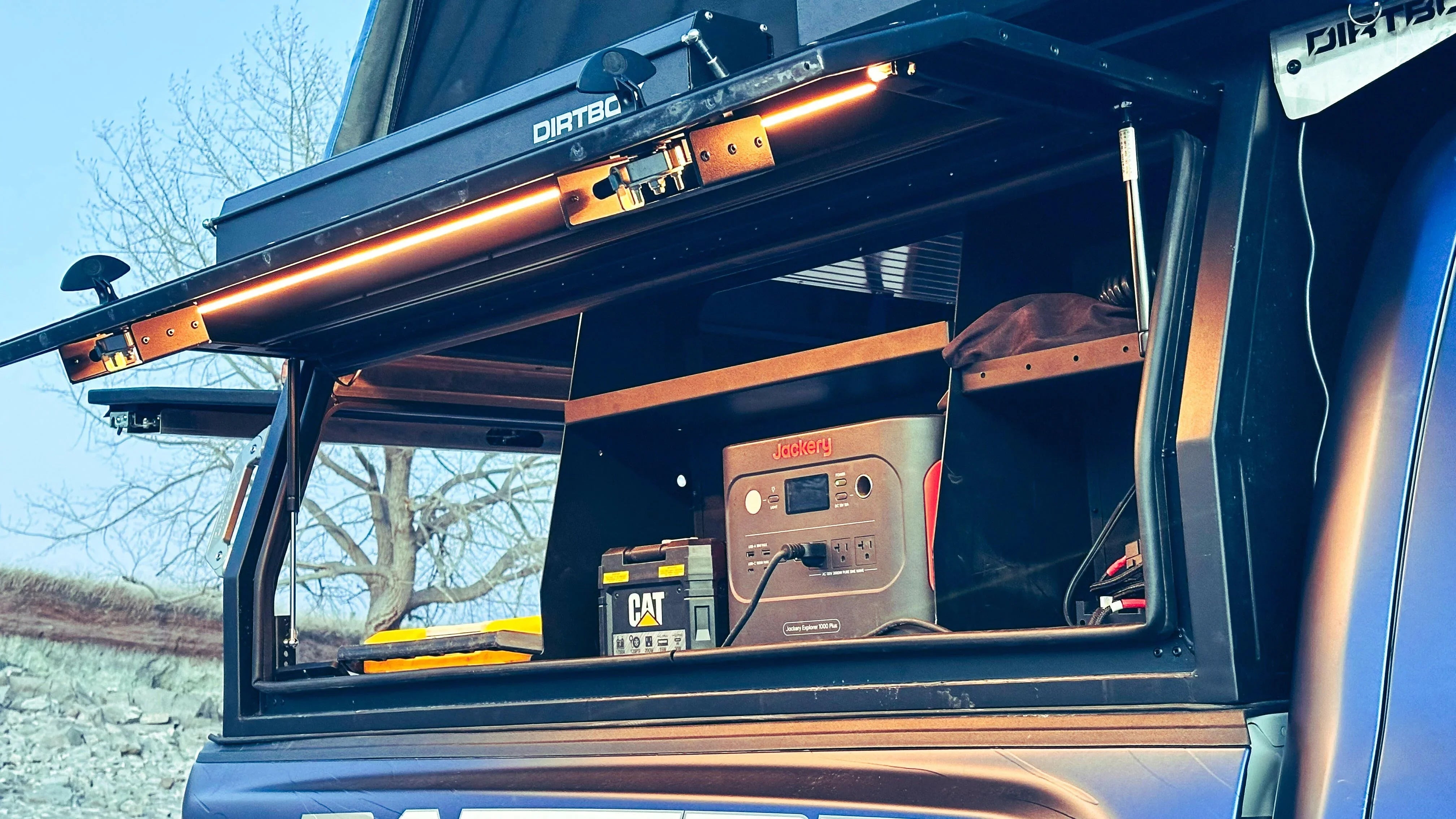 Truck bed storage with portable power station and gear for overlanding or camping