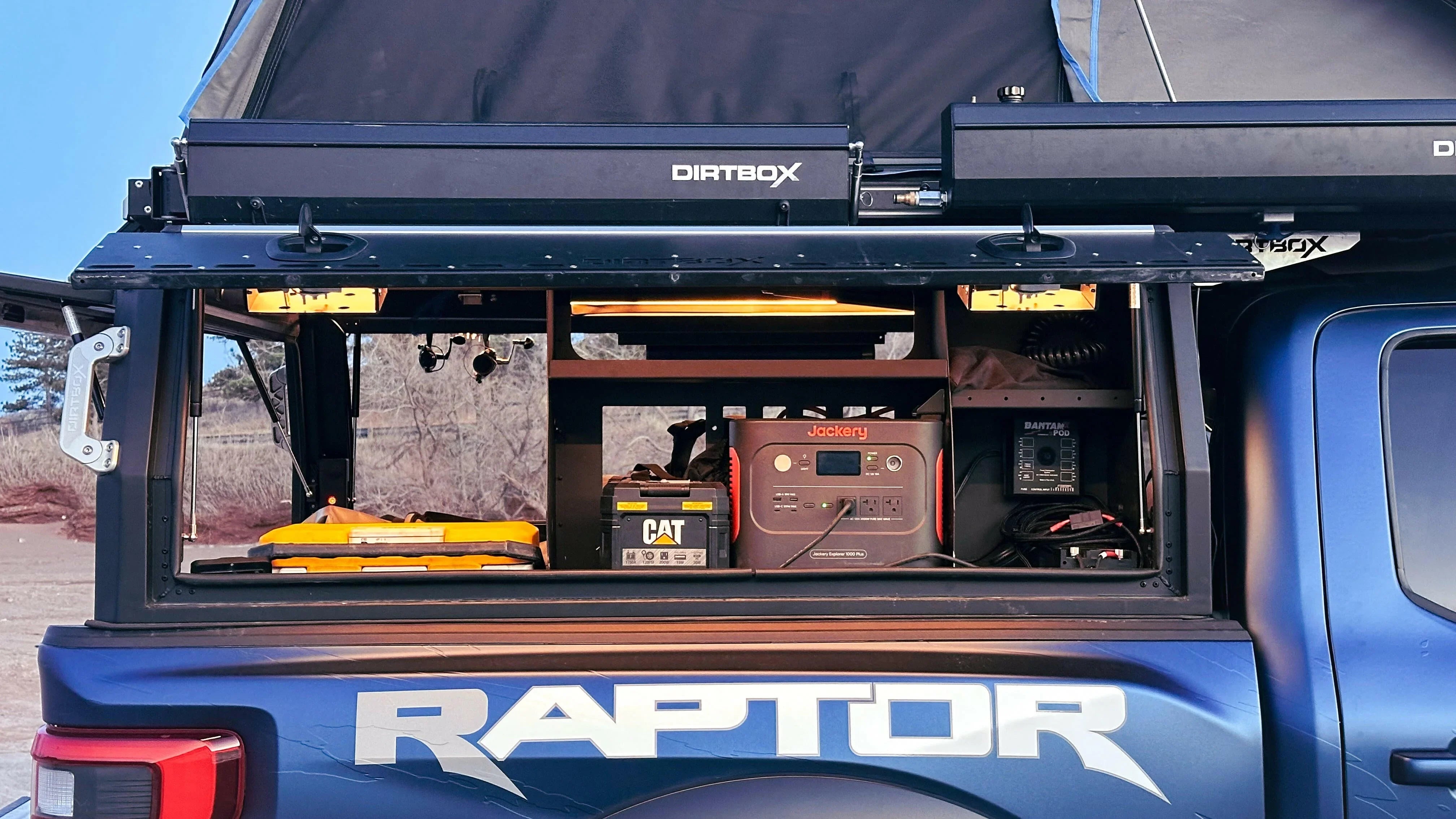 Overlanding truck with Dirtbox canopy, portable power station, battery, and camping gear