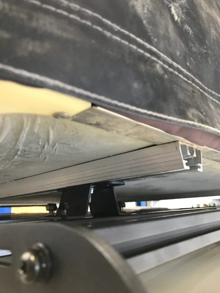 Close-up of roof top tent mounting bracket and hardware on vehicle roof rack
